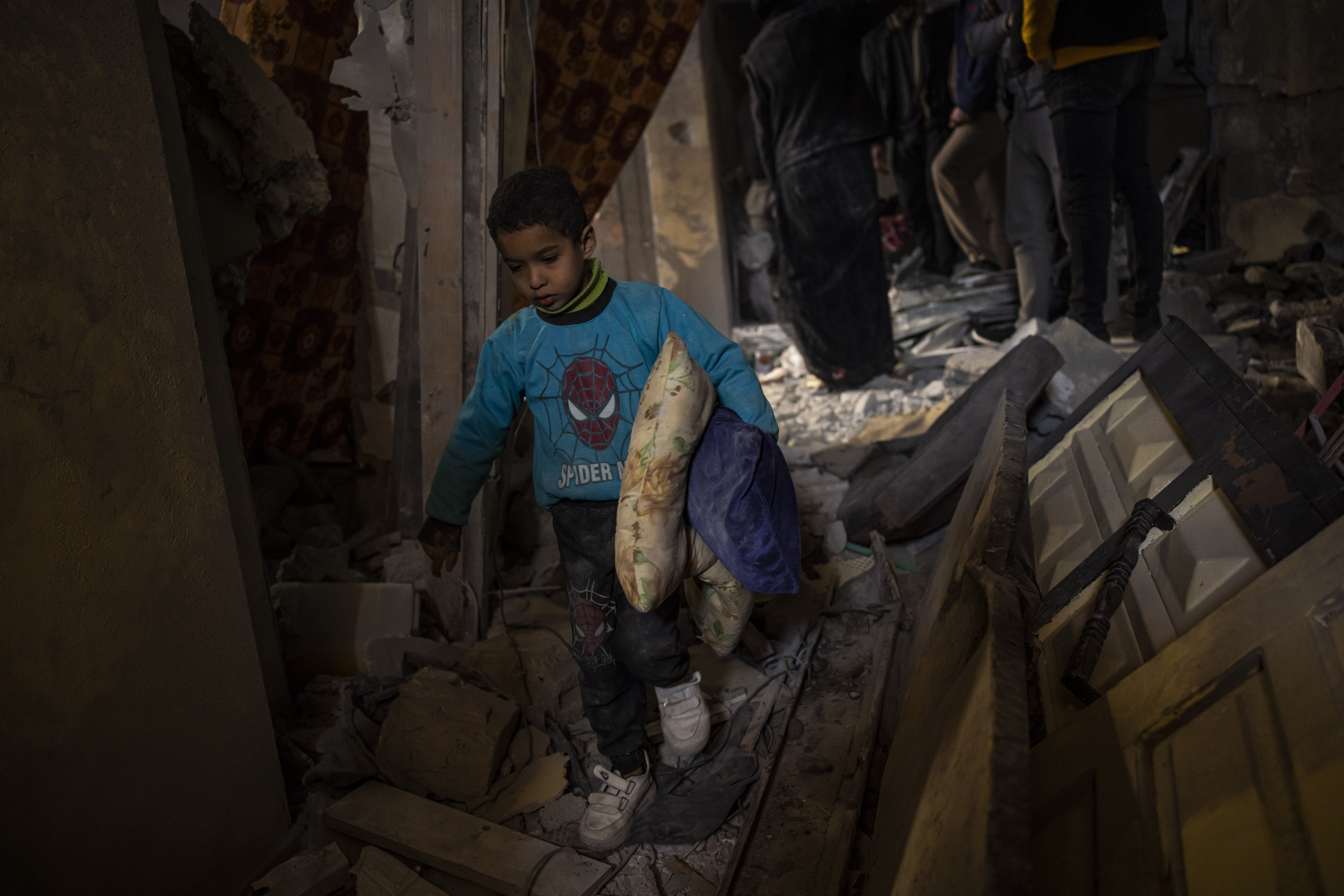 Palestinians collect their belongings from their damaged house after an Israeli airstrike in Rafah, southern Gaza Strip. Photo / AP