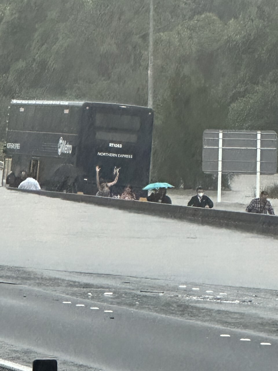 Commuters exit a bus caught in traffic chaos on Auckland's Northern motorway. Photo / Supplied