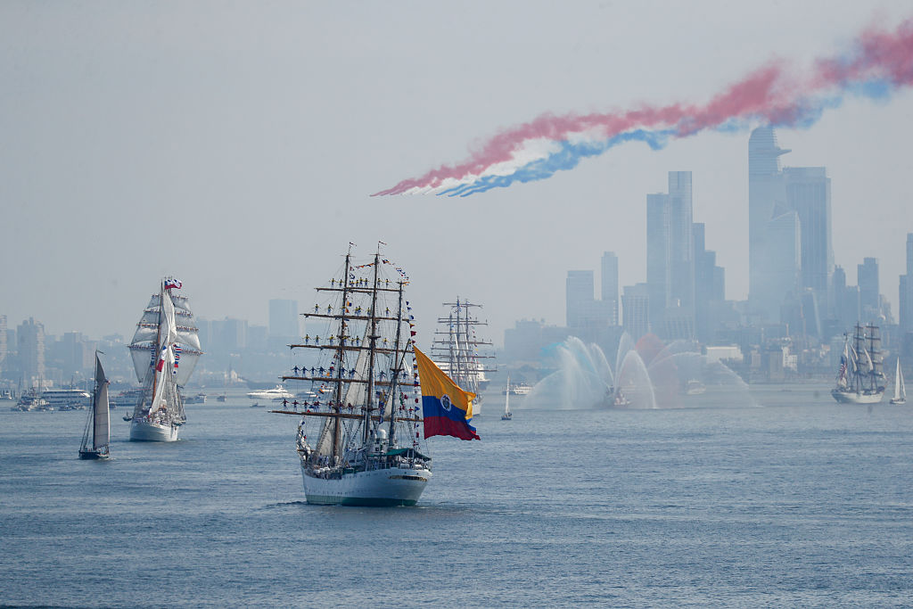 Tall ships with the Manhattan skyline in the distance and the red, white and blue aftermath of a flyover in the sky. Photo / Bloomberg via Getty Images