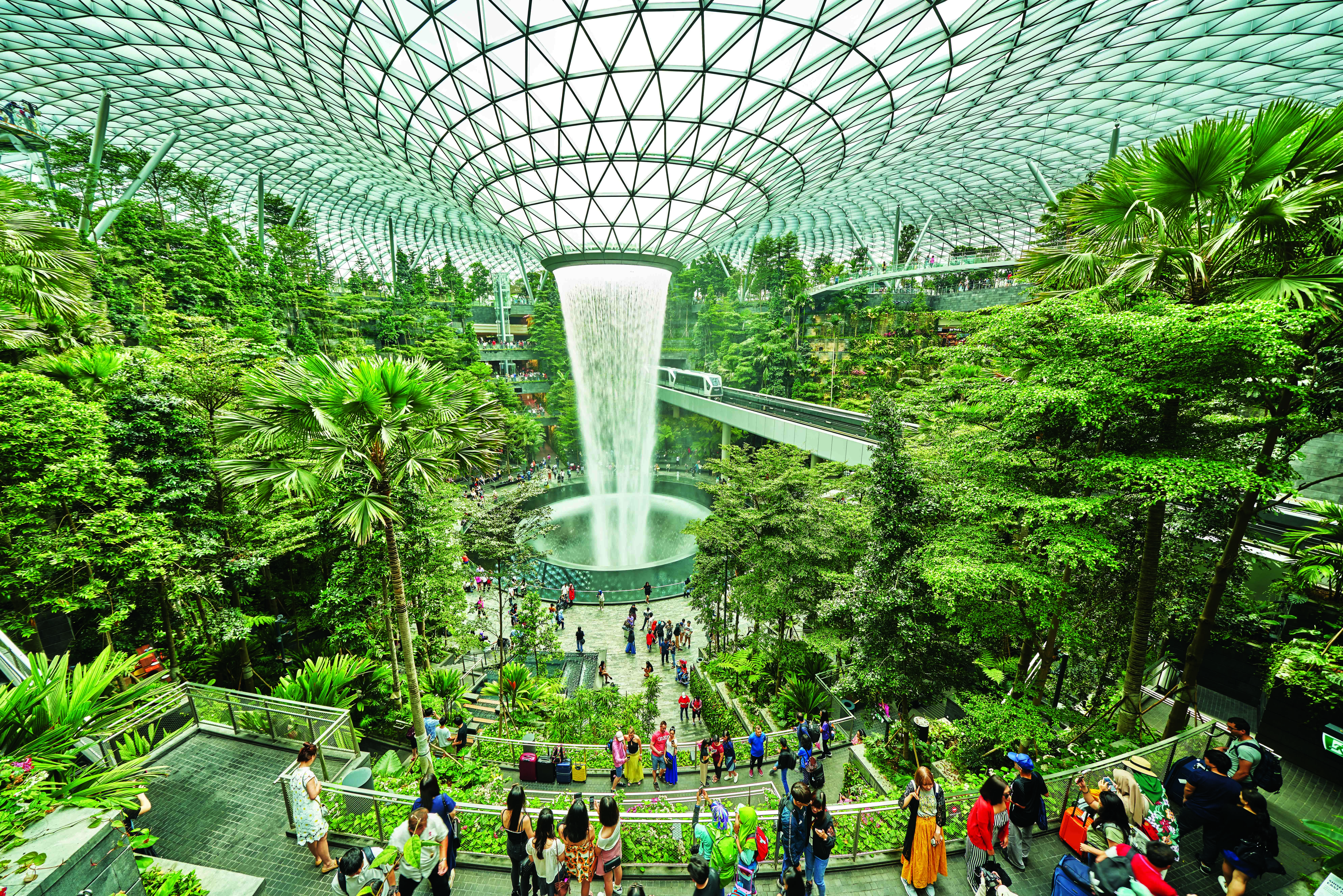 The HSBC Rain Vortex is a stunning 40m tall indoor waterfall. This marvel appears to cascade from the ceiling of a large, plant-filled atrium. Photo / Changi Airport Group