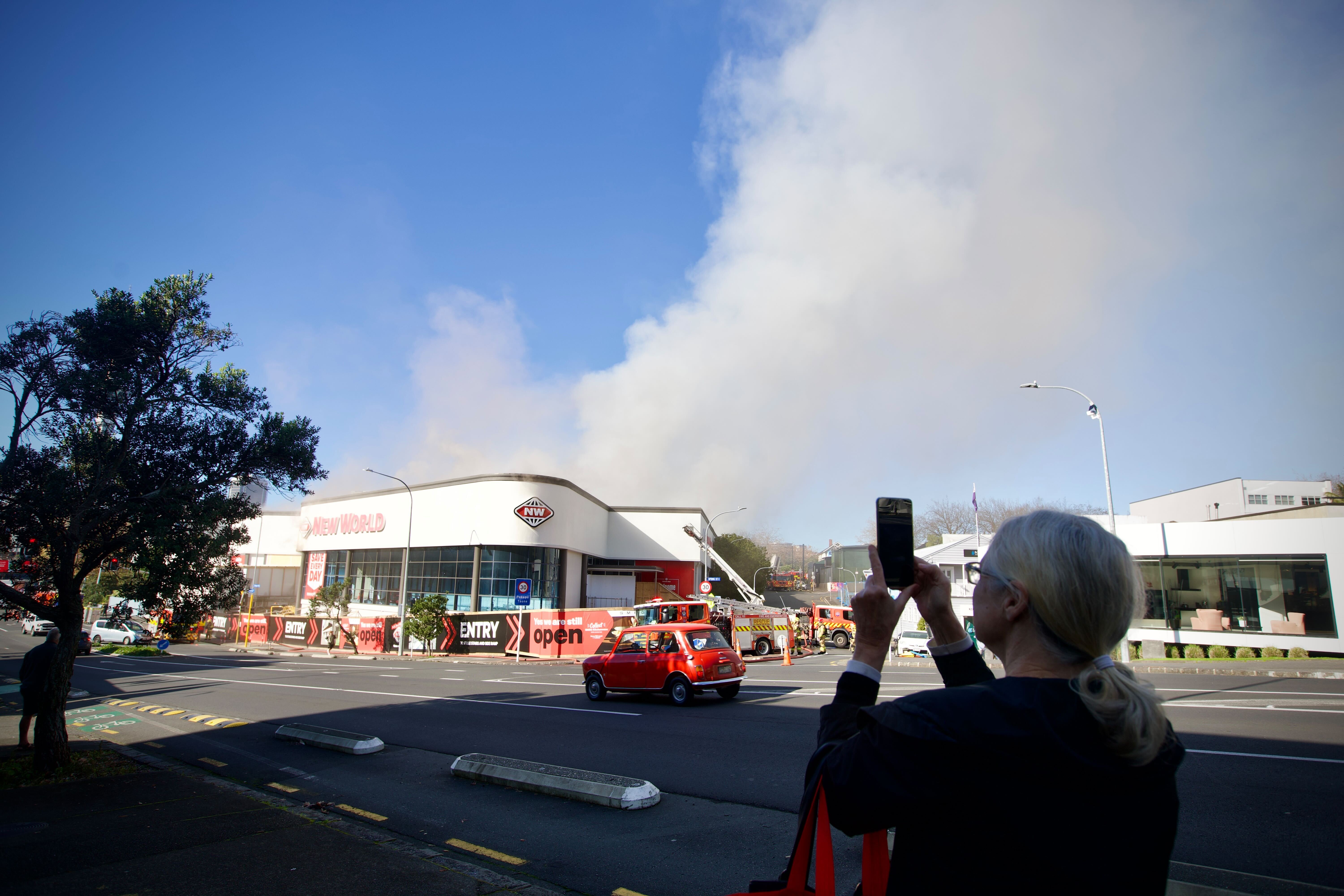 Smoke continues to billow out from the New World Supermarket. Photo / Jason Dorday