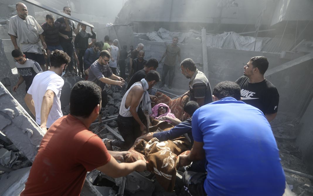 Palestinians carry an injured woman after being rescued from under the rubble of a destroyed building following an Israeli airstrike in Bureij refugee camp, Gaza Strip. Photo / AP