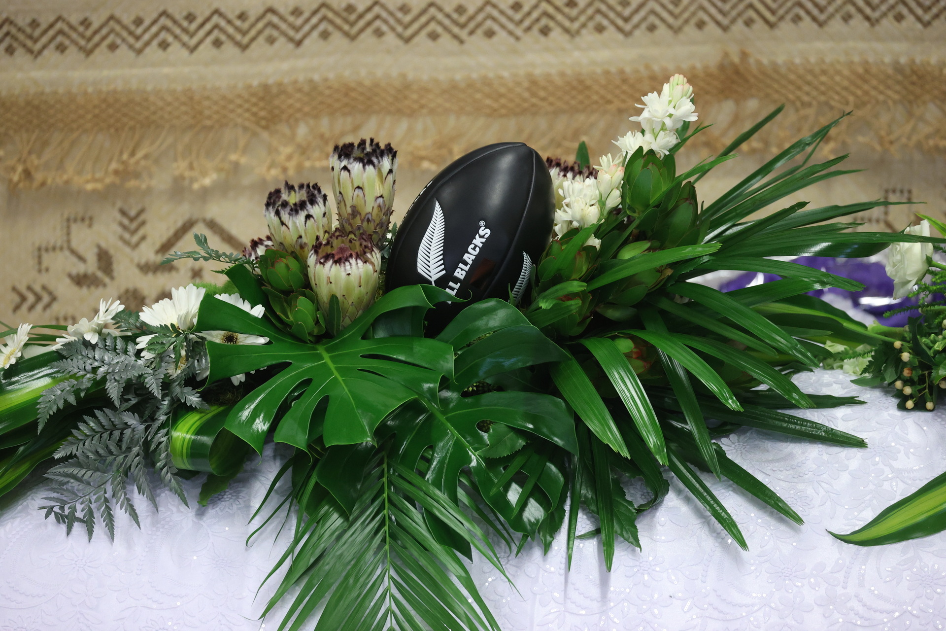 A mini All Black rugby ball set among a spray of flowers and foliage sat atop the casket of former All Black Va'aiga Tuigamala at his funeral in Auckland today. Photo / Brett Phibbs