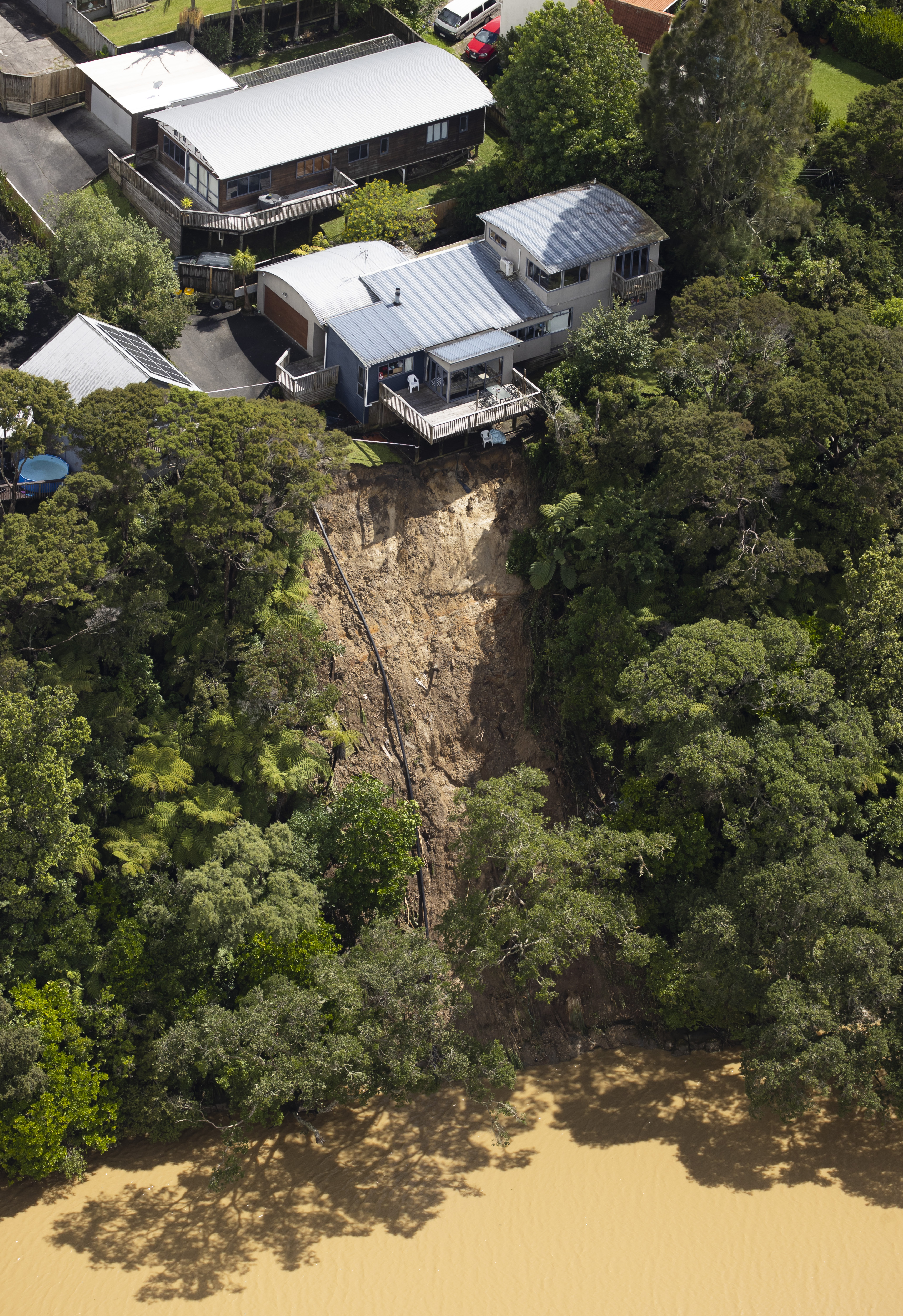Landslides threaten homes on Colwill Rd, Massey following a record deluge of rain which caused major flooding across the Auckland region. Photo / Brett Phibbs
