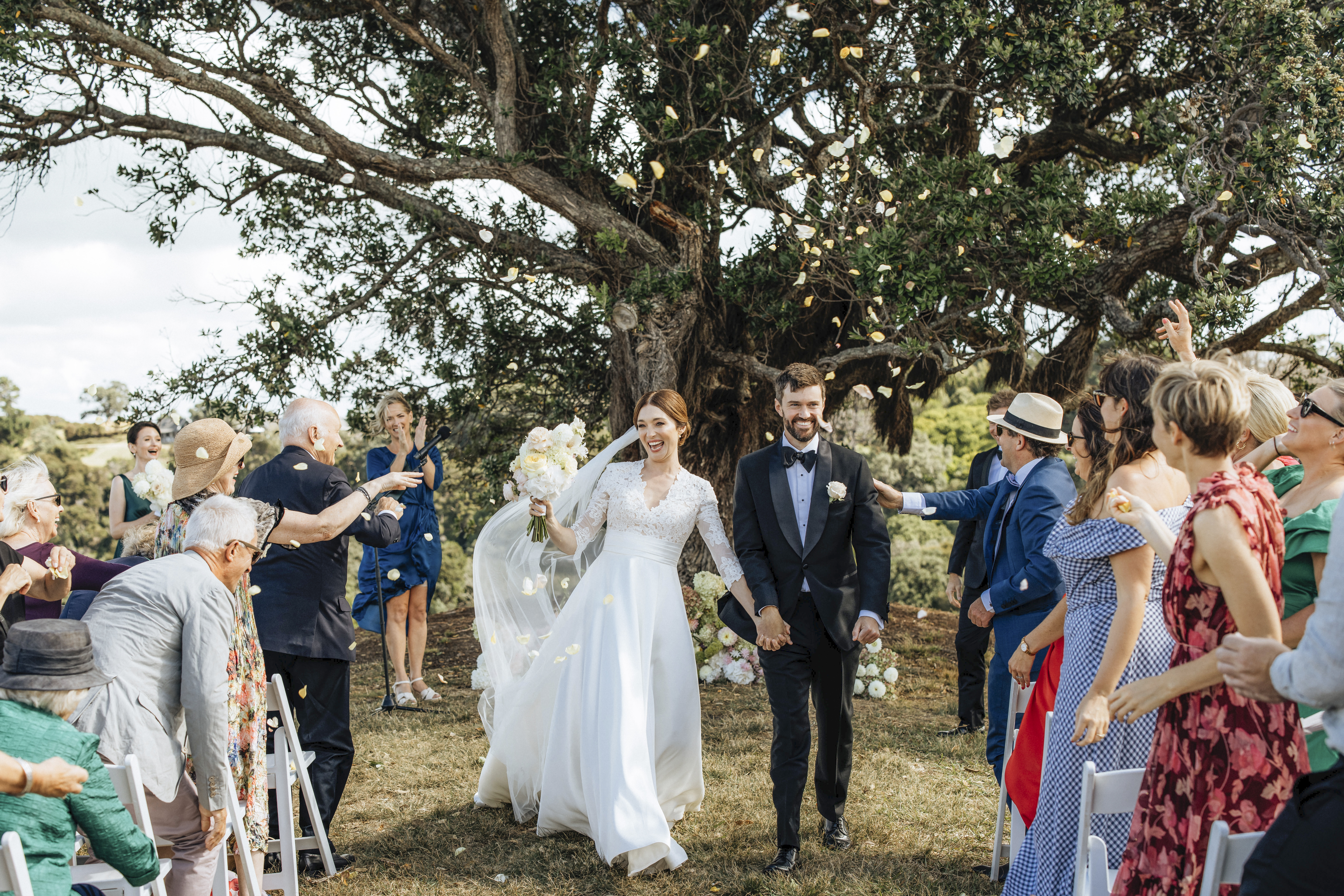 The jubilant newlyweds walk back up the aisle with The Waterboys classic The Whole Of The Moon blaring. Photo / Wildfolk Photography