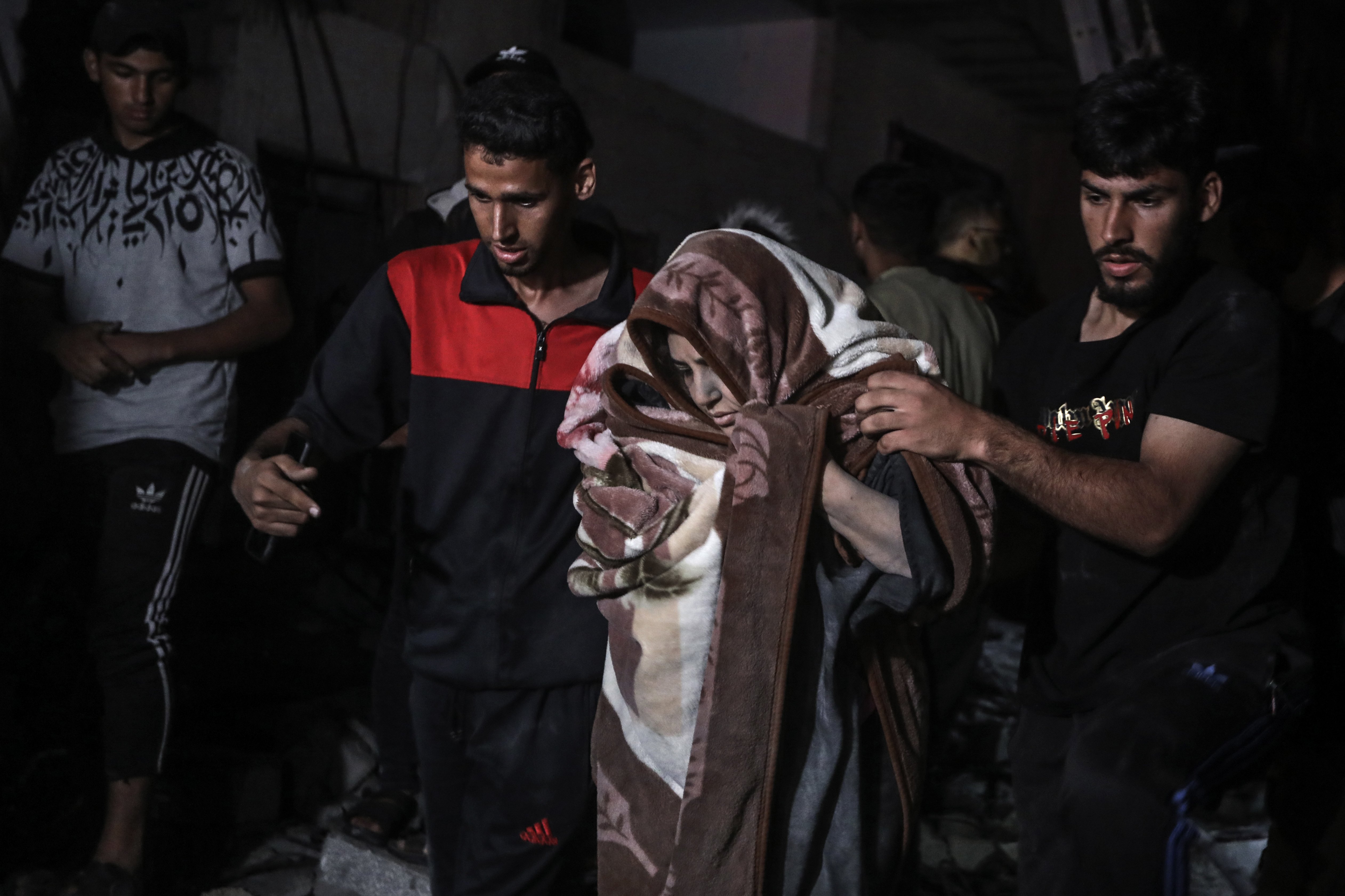 Palestinians rescue a woman who survived an Israeli bombardment on a residential building in Rafah. Photo / AP