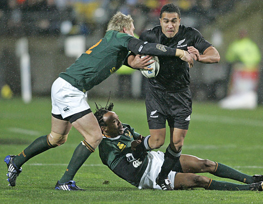 Mils Muliaina of the All Blacks is tackled by Jean de Villiers of South Africa. Photo / Mark Mitchell