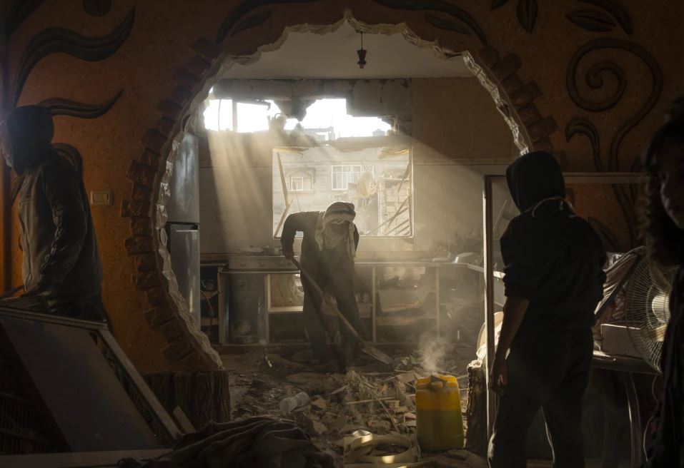 Palestinians look at their neighbour's damaged house following an Israeli strike in Rafah. Photo / AP