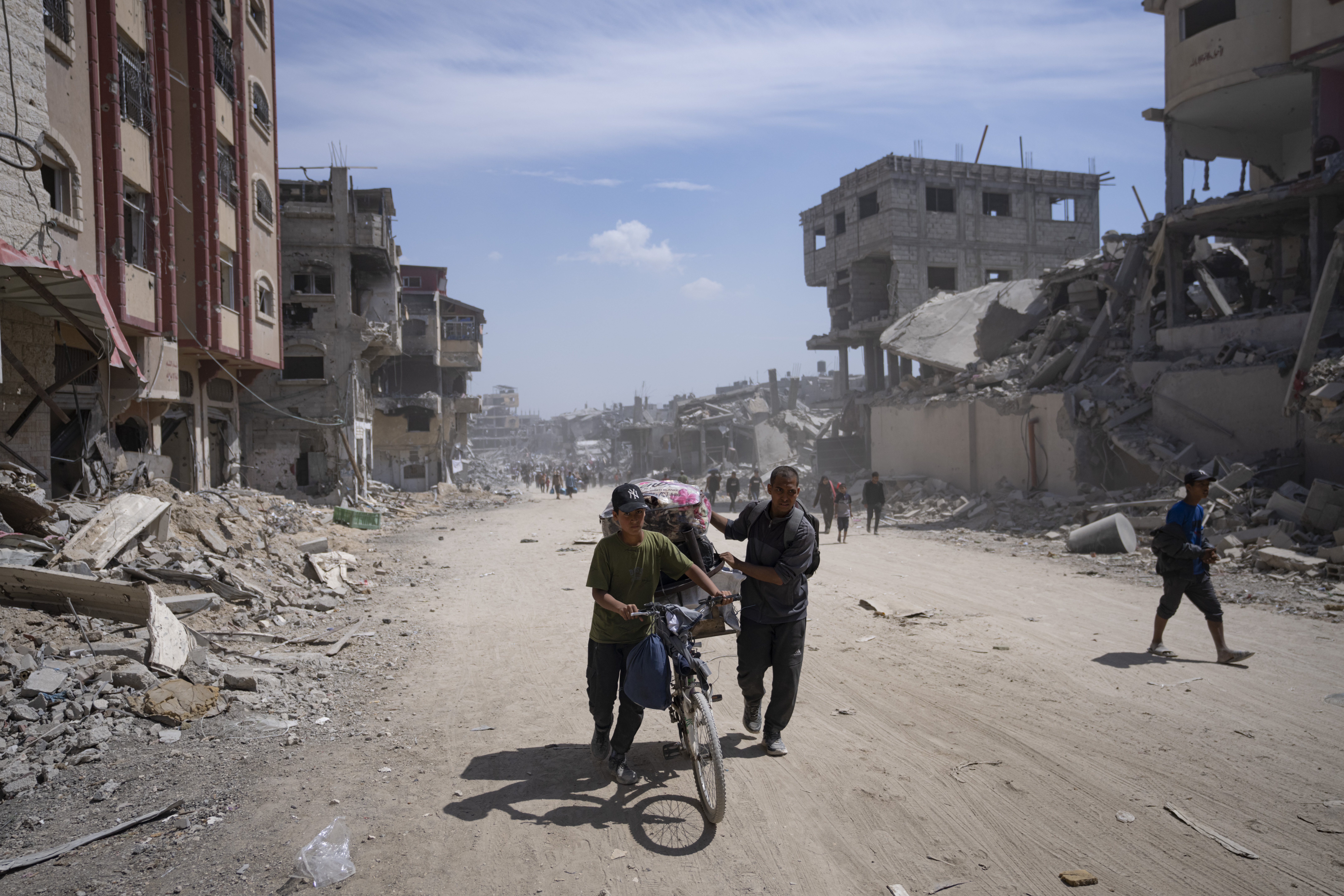 Palestinians walk through the destruction in the wake of an Israeli air and ground offensive in Khan Younis, southern Gaza Strip. Photo / AP