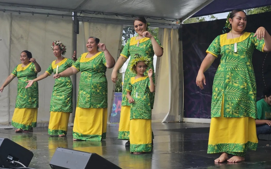 A group of Tokelaun ladies share the stage with a young one who has expressed great interest in her cultural dance practices. Photo / RNZ / Tiana Haxton