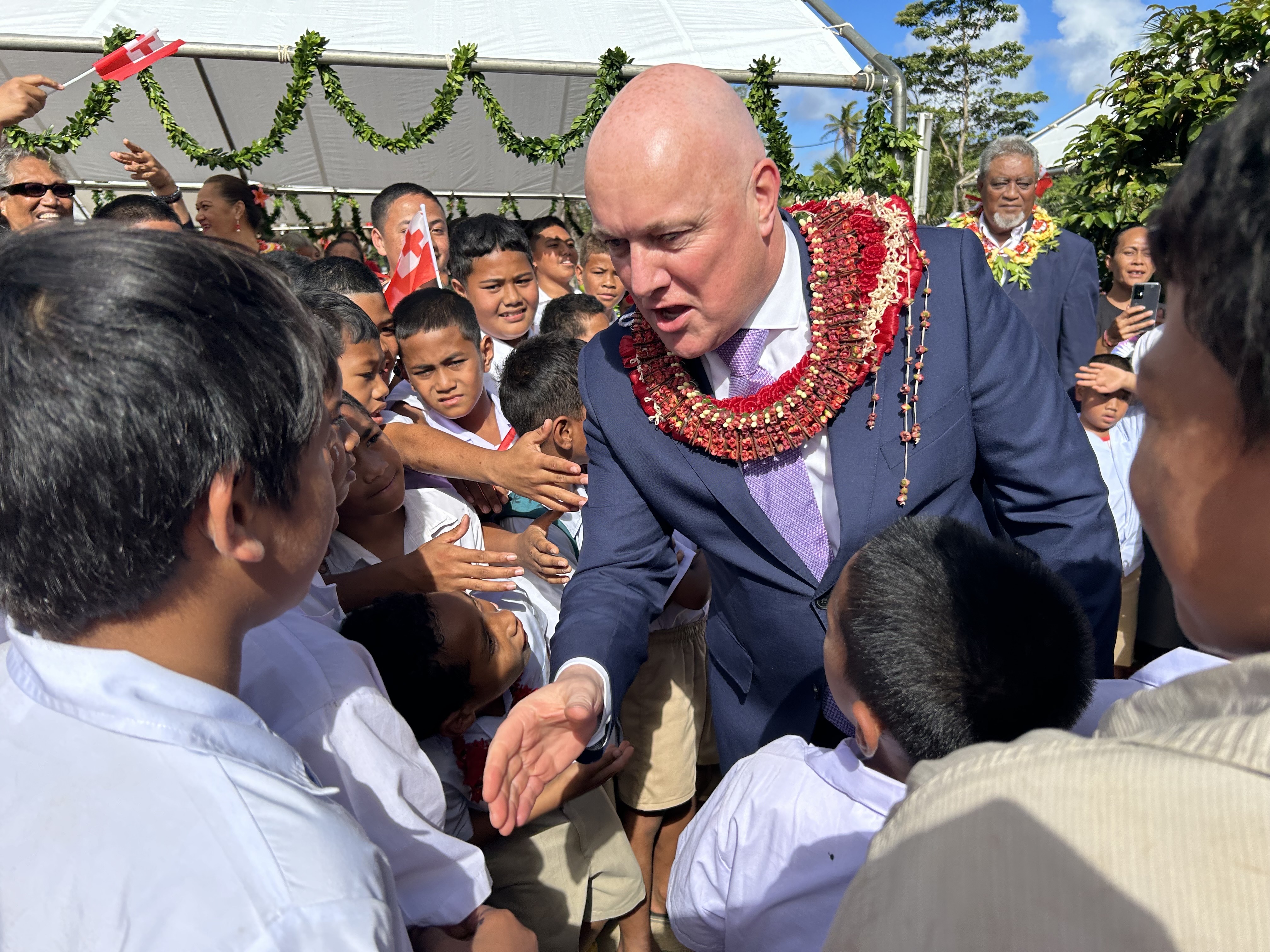 Prime Minister Christopher Luxon shakes as many hands as he can during his visit to GMS Tokomololo School in Tonga. Photo / Adam Pearse
