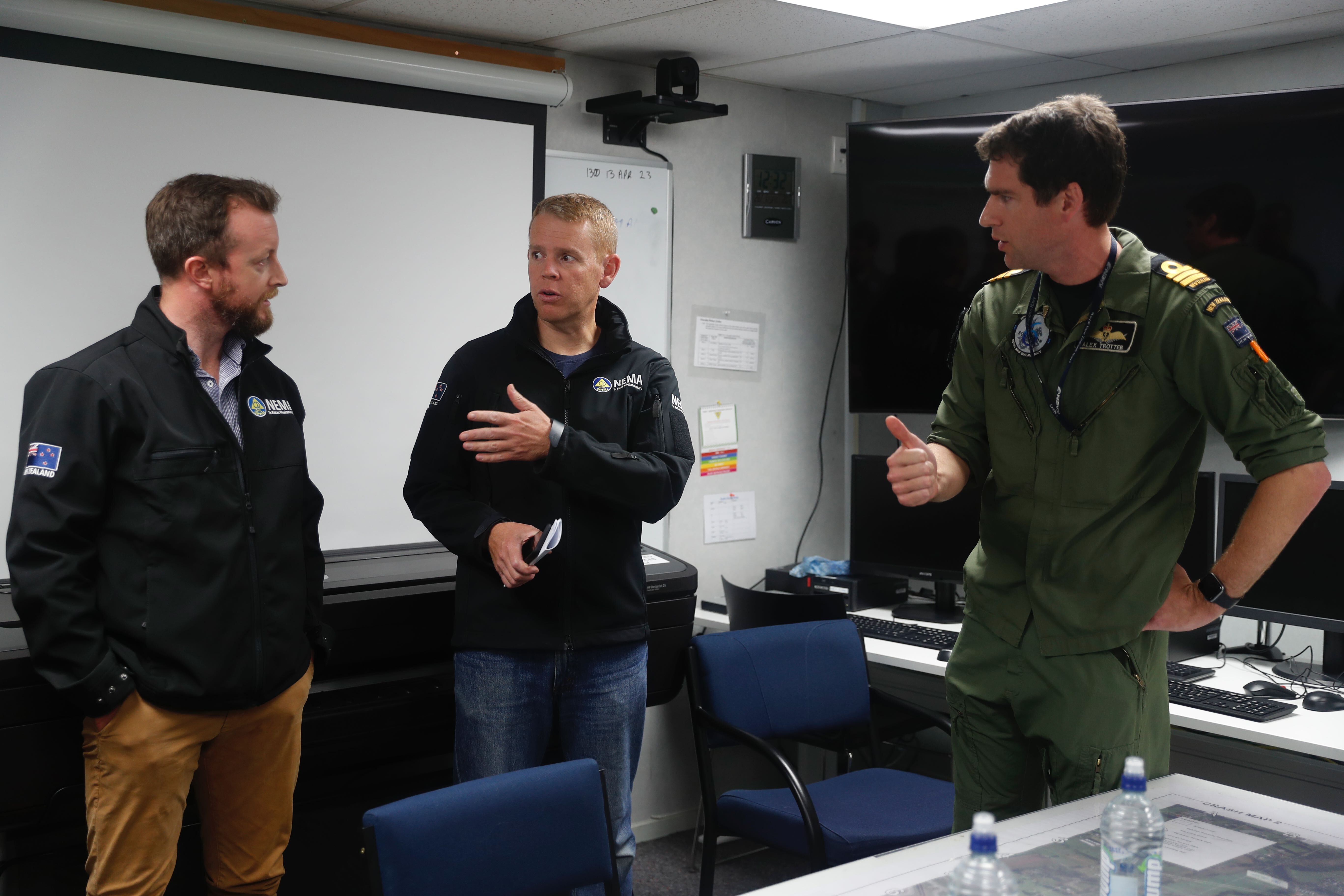 Prime Minister Chris Hipkins, centre, and emergency minister Kieran McAnulty are briefed on the Auckland floods. Photo / Dean Purcell