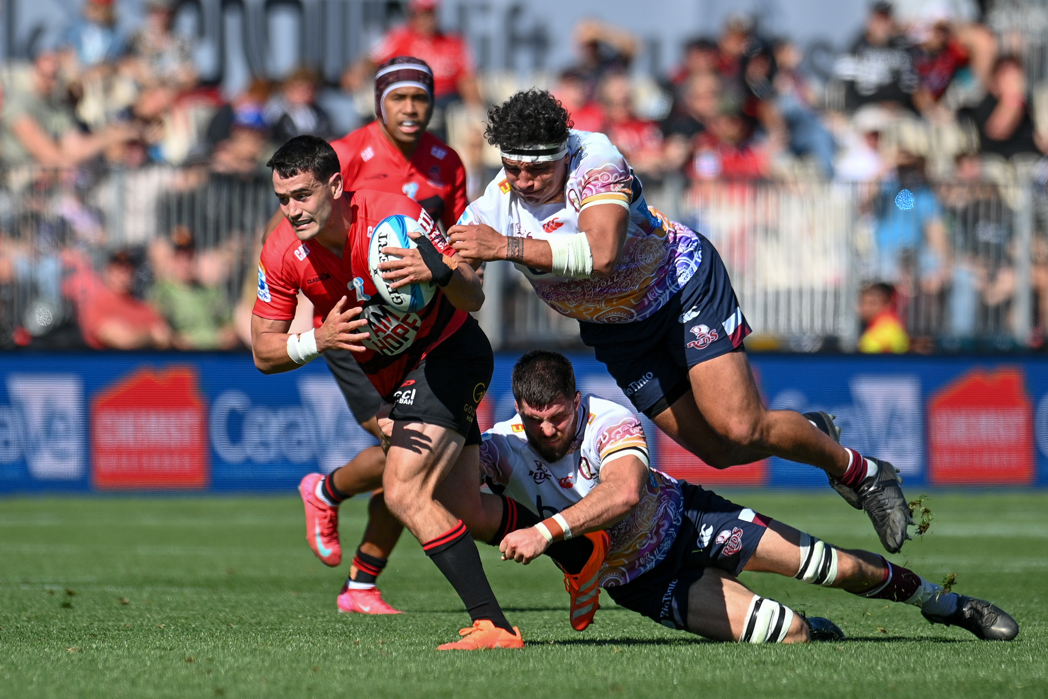 Will Jordan of the Crusaders eludes Liam Wright and Alex Hodgman of the Reds during the Crusaders vs Reds Super Rugby Pacific match at Apollo Projects Stadium in Christchurch on March 9. Photo/ Photosport