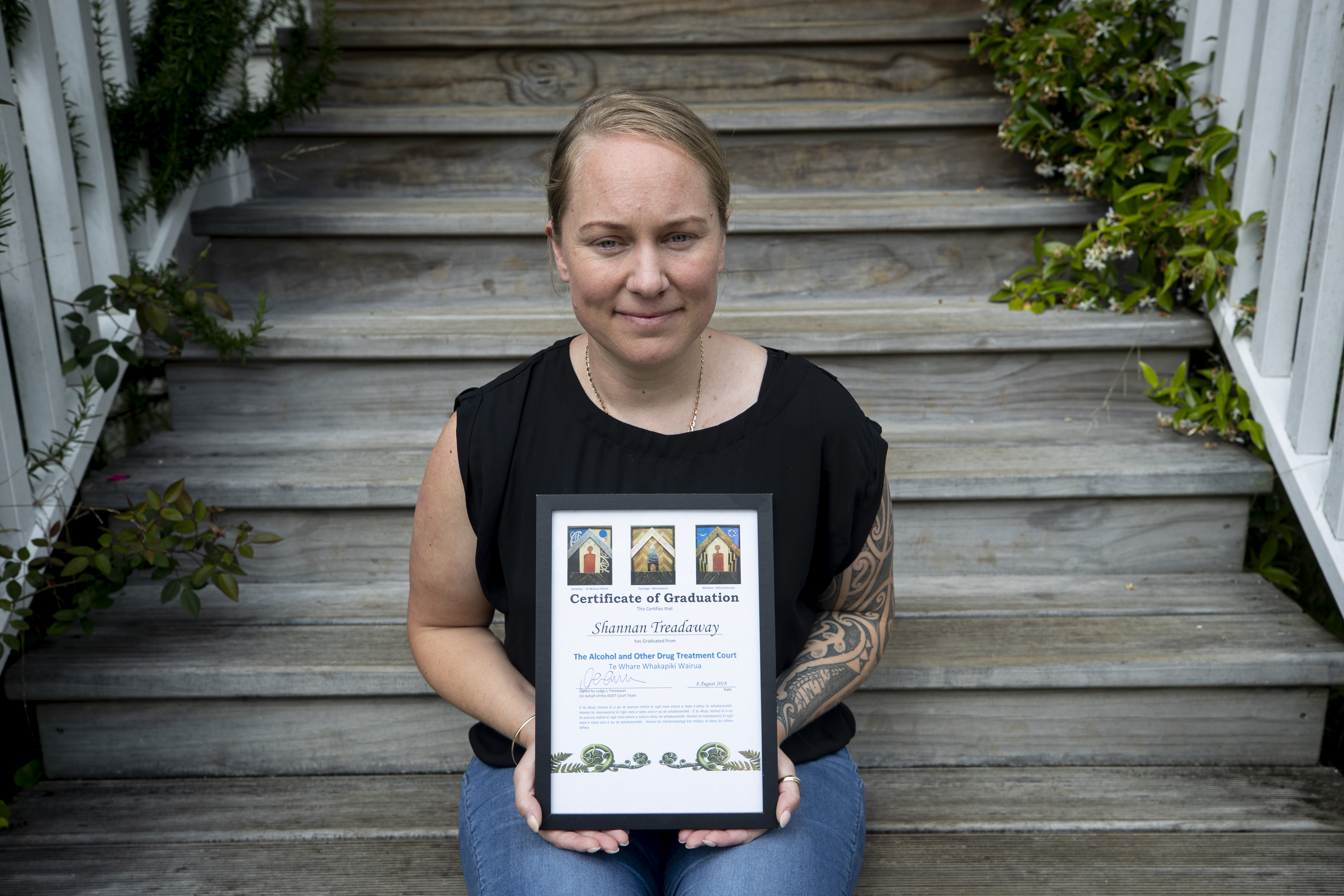 Hill holds her framed graduation certificate at her Auckland home. It uses her old last name, Treadaway. Photo / Dean Purcell