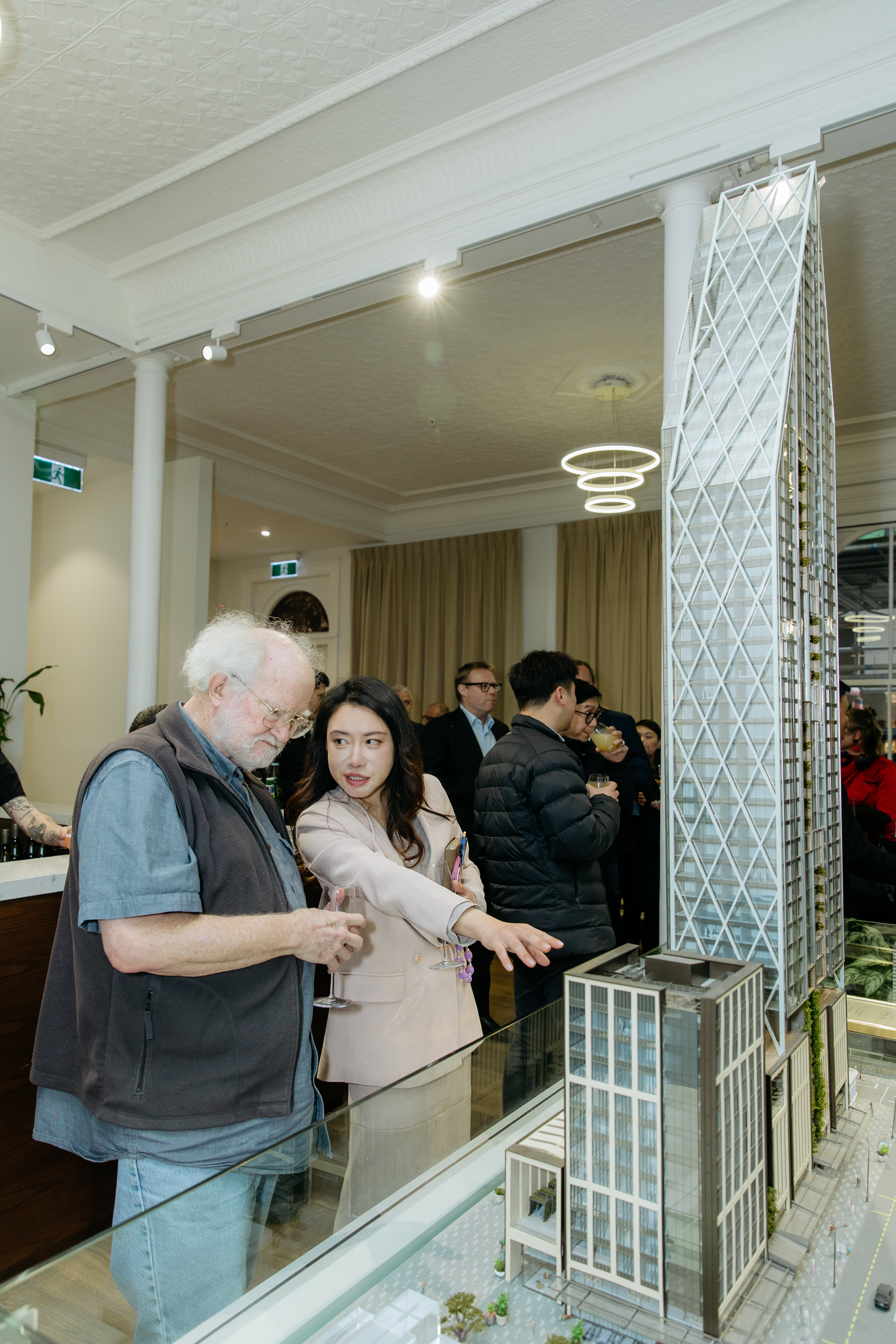 Bayleys agent Carol Cong (right) shows the display of the soaring tower off to Michael McKeown at a Seascape apartment tower event held in Auckland. Photo / Mala Photography