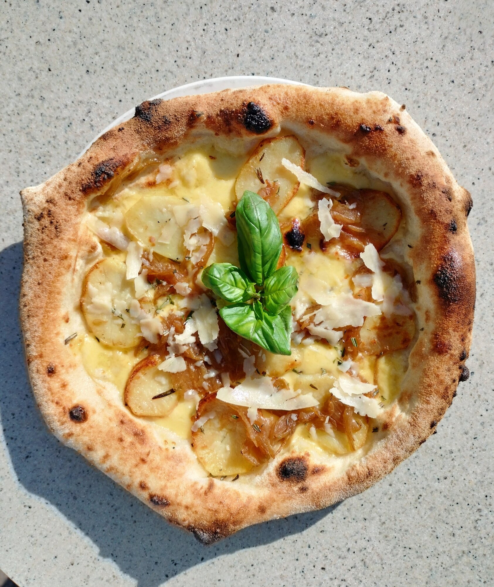 The potato pizza at Esplanade was served with fresh basil and sliced parmesan.