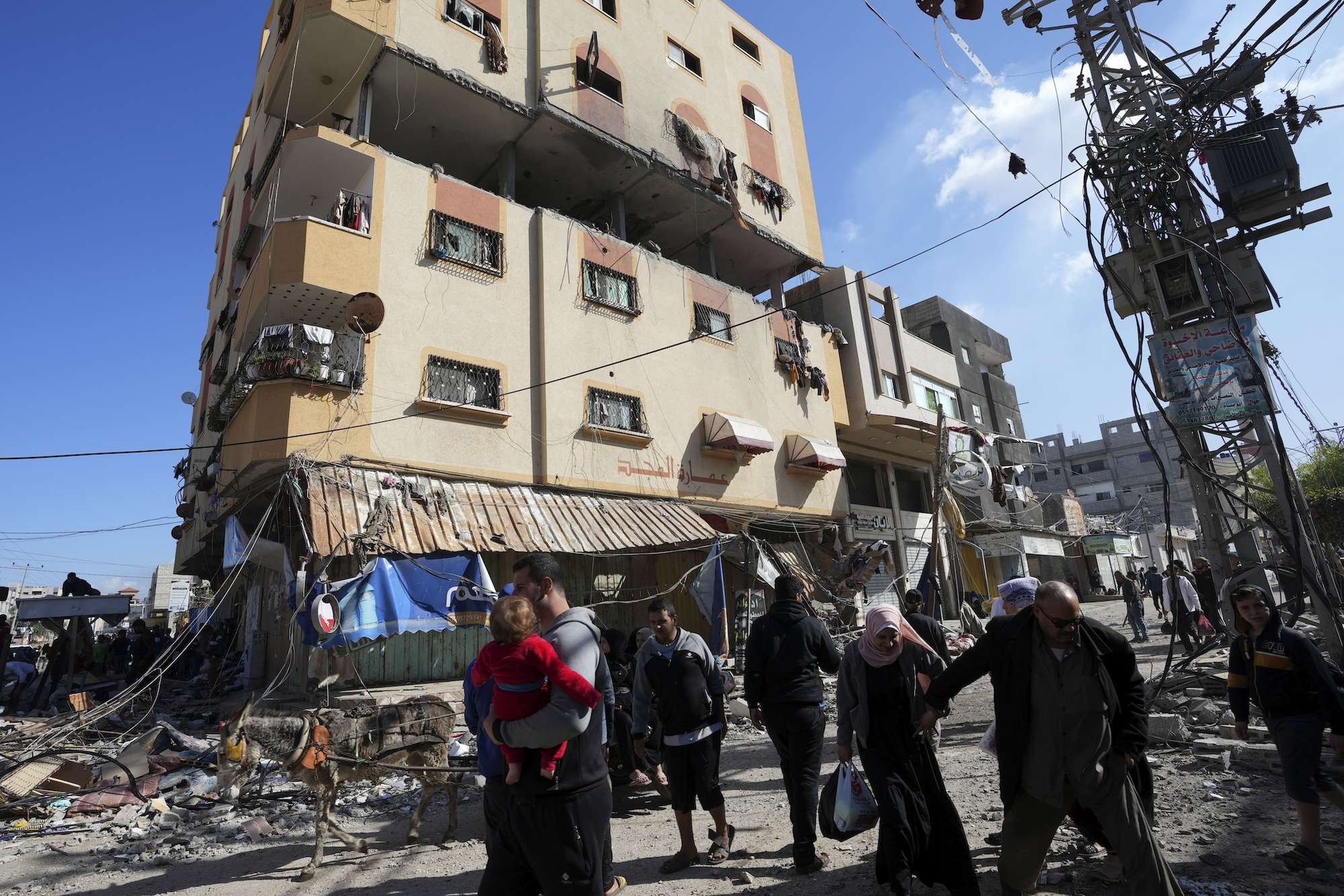 Palestinians gather in front of a building hit by an Israeli strike in Nusseirat refugee camp on the Gaza Strip. Photo / AP