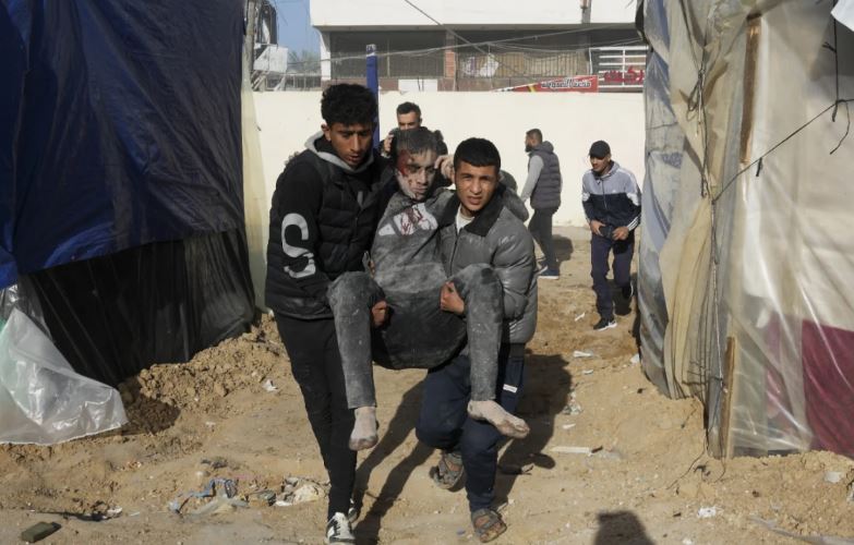 Palestinians evacuate wounded after an Israeli strike hit a building next to Al-Aqsa Hospital in Deir al Balah, Gaza Strip, on Wednesday. Photo / AP