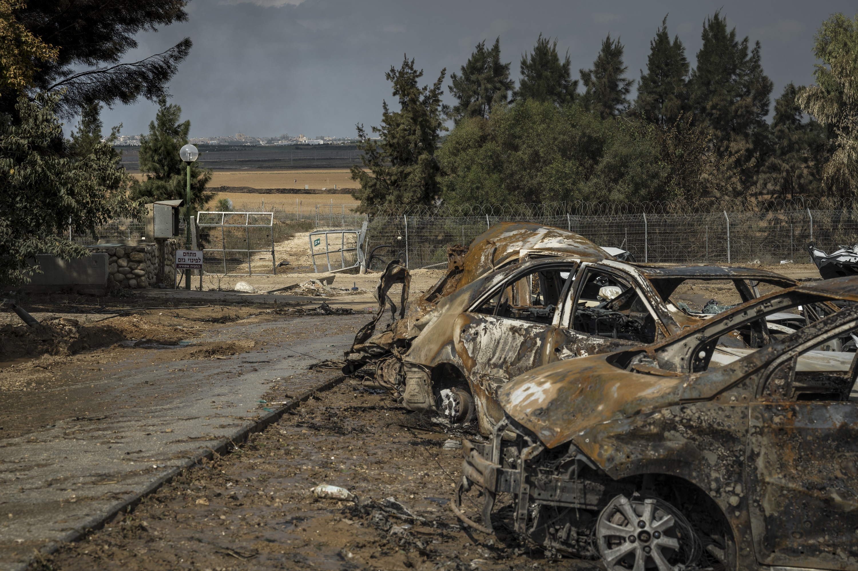 Smoke billowing from Gaza City is seen through the security fence in Kfar Azza, a village just across the border from Gaza that was attacked by gunmen. Photo / Sergey Ponomarev, The New York Times