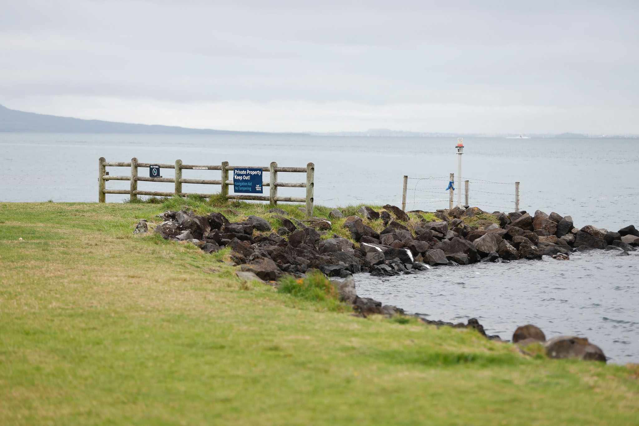 The grassy shore in Gulf Harbour where the angler hooked the plastic bags containing the woman's remains. Photo / Michael Craig