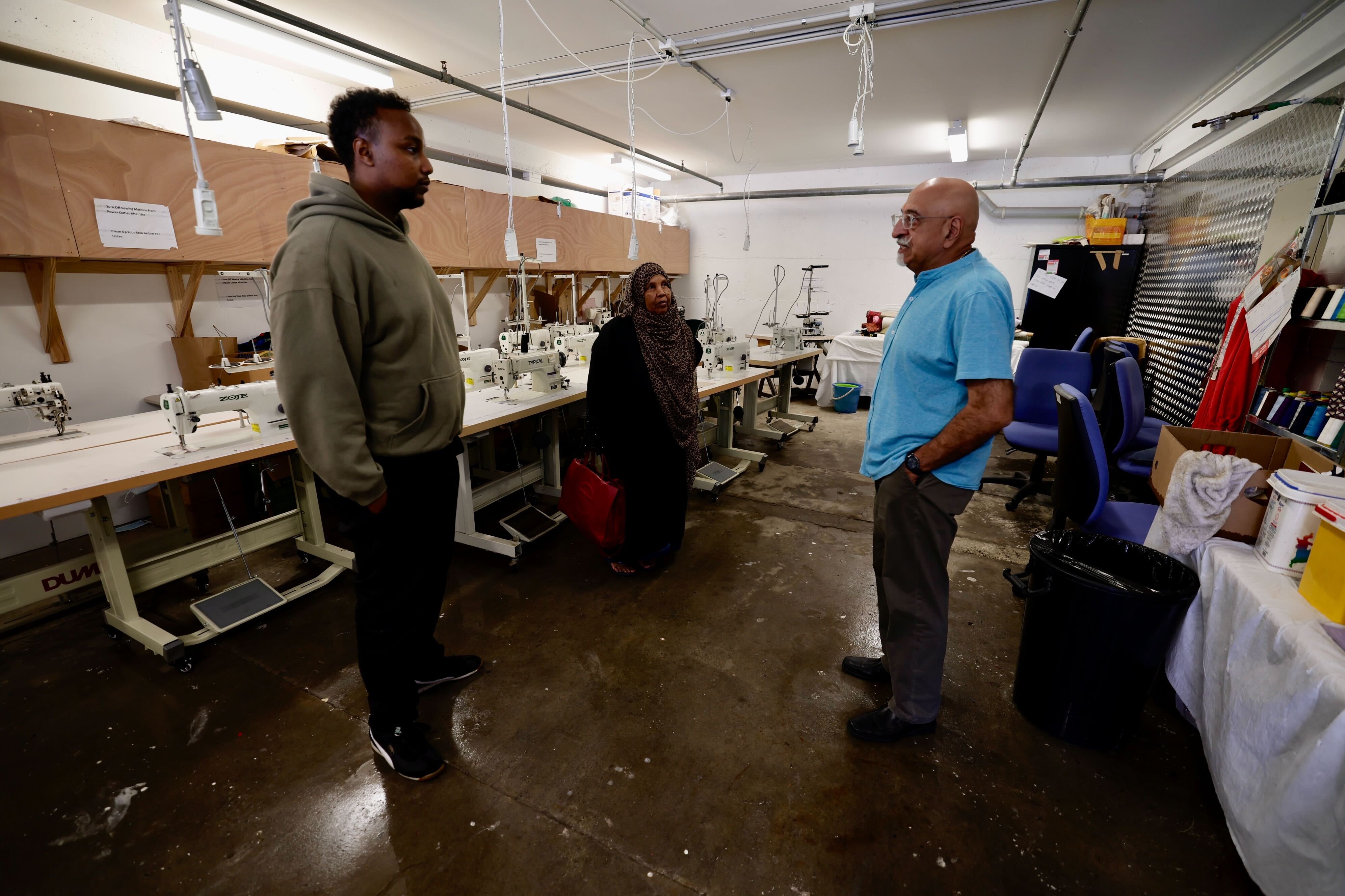 Harish Lodhia speaks with Mohamed Abdul Kadir and Fadumo Ahmed, whose non-profit group The Ethnic Women's Trust lease out his Mt Roskill property on Stoddard Rd. Photo / Dean Purcell