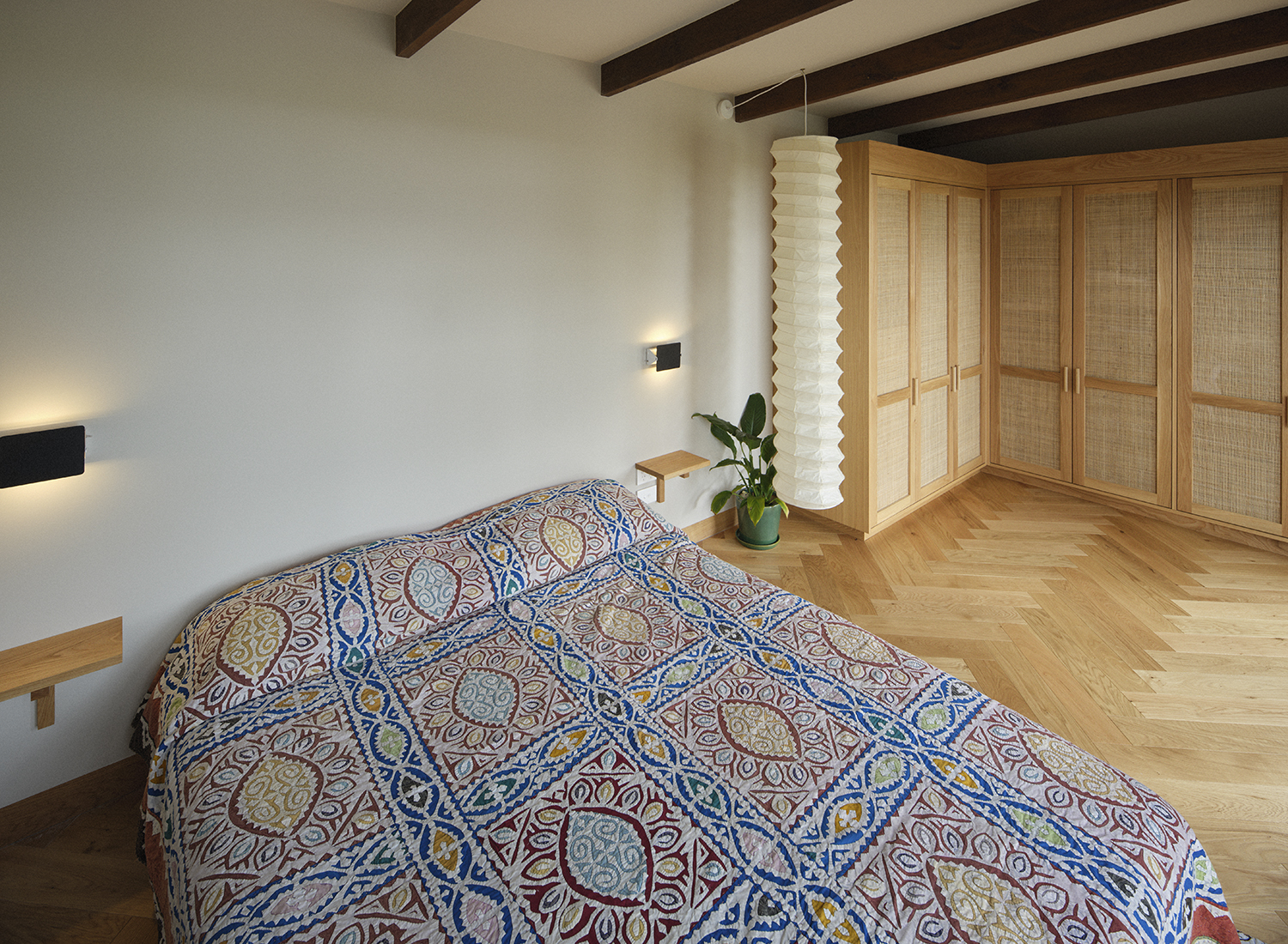 The bedroom space is a minimal zone with a vintage quilt taking centre stage. Photo / Derek Henderson