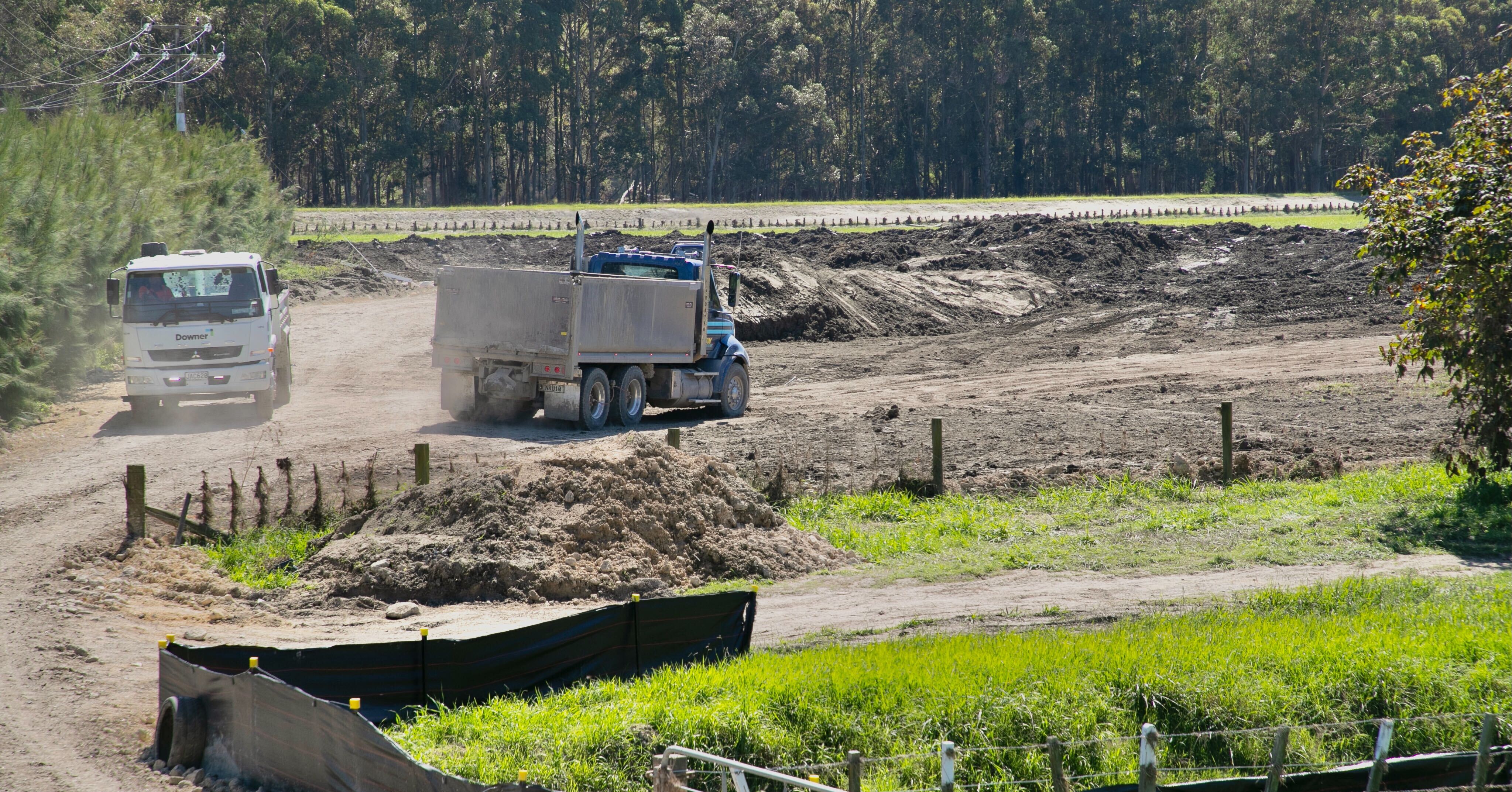 Farmers are dealing with kilometres of broken fences and paddocks covered by silt. These trucks are dropping off large amounts of silt at a deposit site near Napier. Photo / Warren Buckland