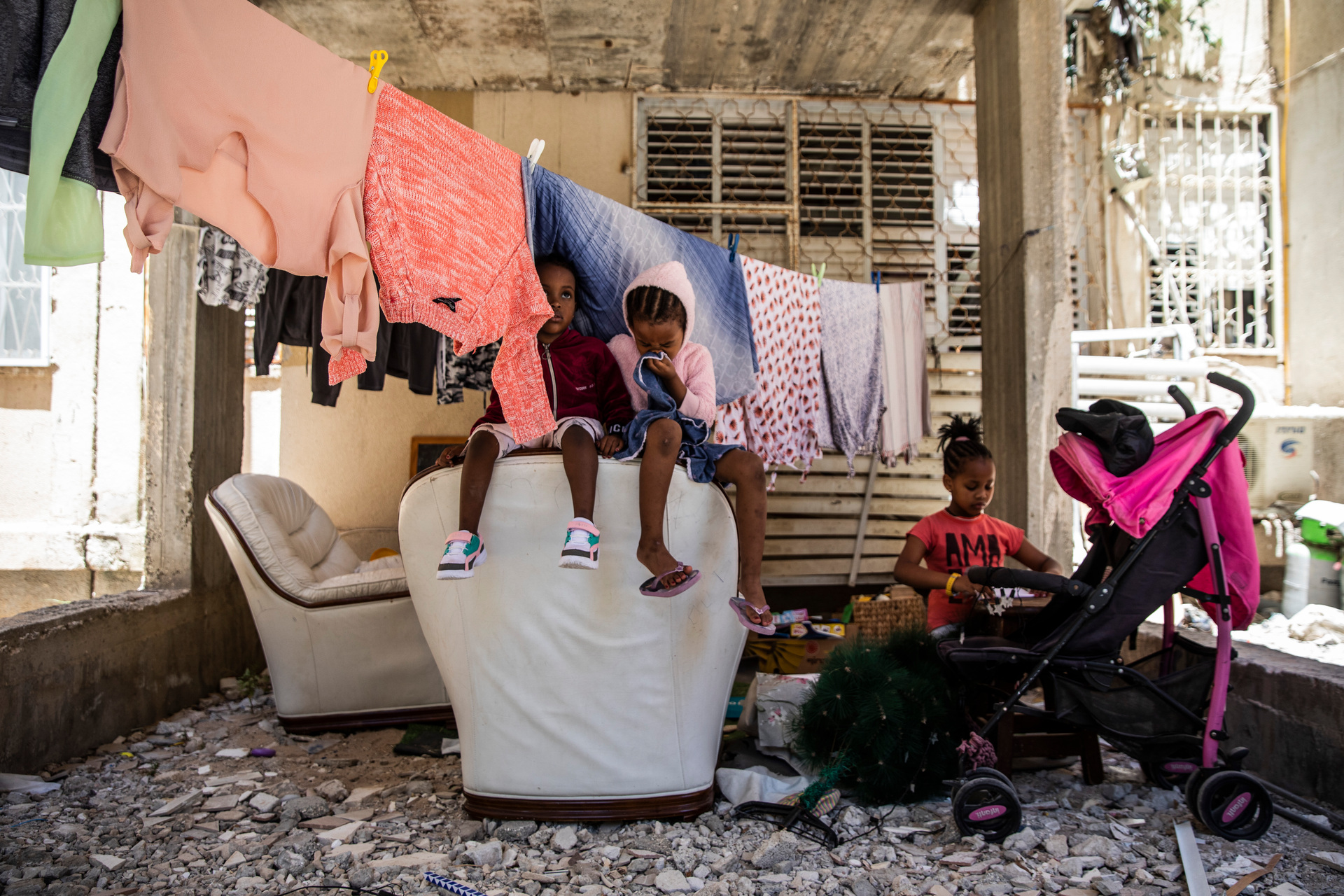 Children sit outside their apartment for the first time in days in Ashdod, Israel before sirens warning of rockets fired from Gaza Strip. Photo / AP