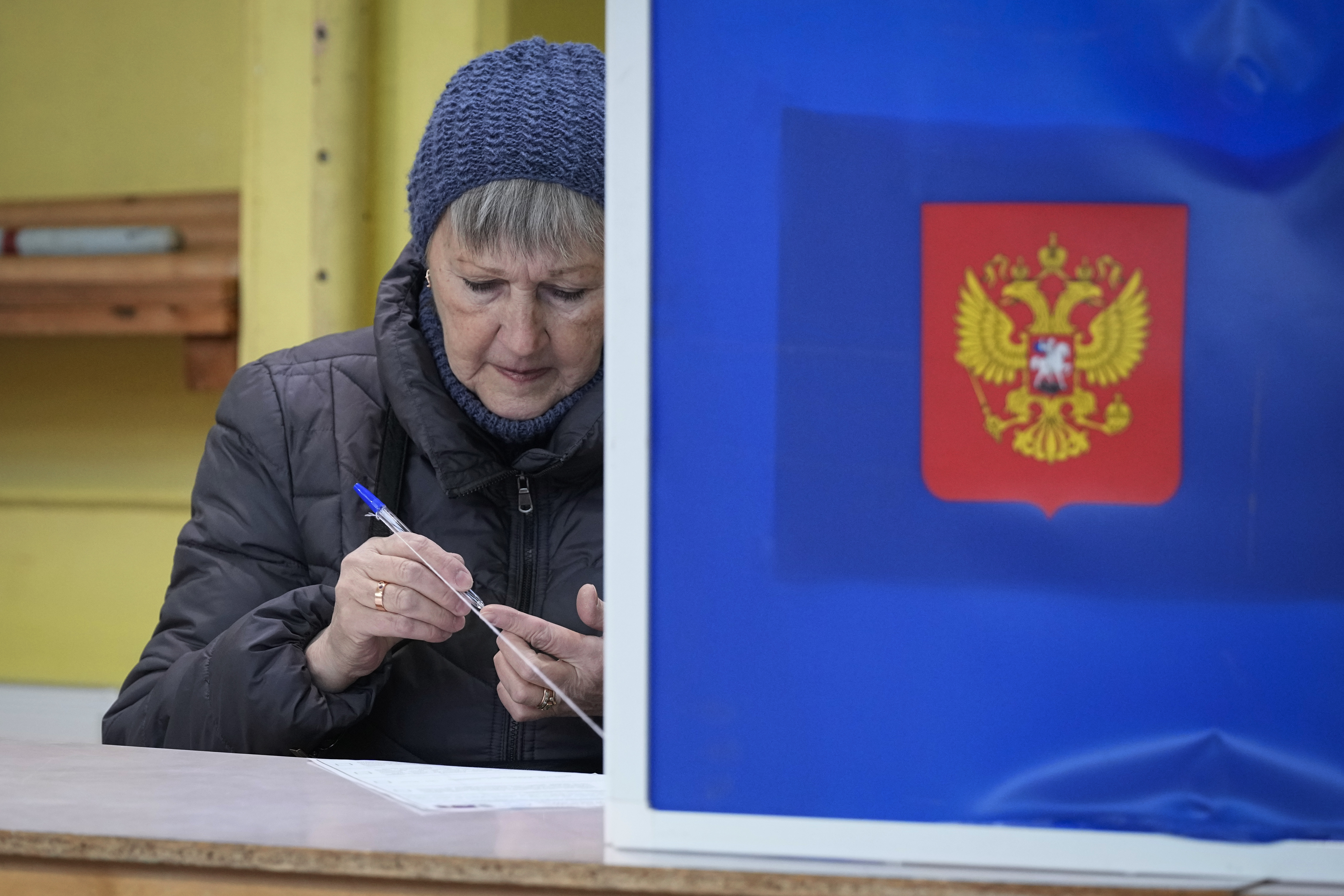 A woman checks a pen prior to fill her ballot at a polling station during the presidential election in St. Petersburg, Russia on March 15. Voters in Russia are heading to the polls for a presidential election that is all but certain to extend President Vladimir Putin's rule after he clamped down on dissent. (AP Photo/Dmitri Lovetsky)