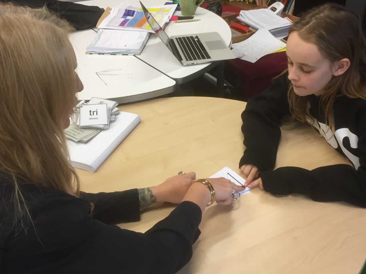 Rebecca Elias (left) uses cards to teach Blair Paltridge, 11, the different ways