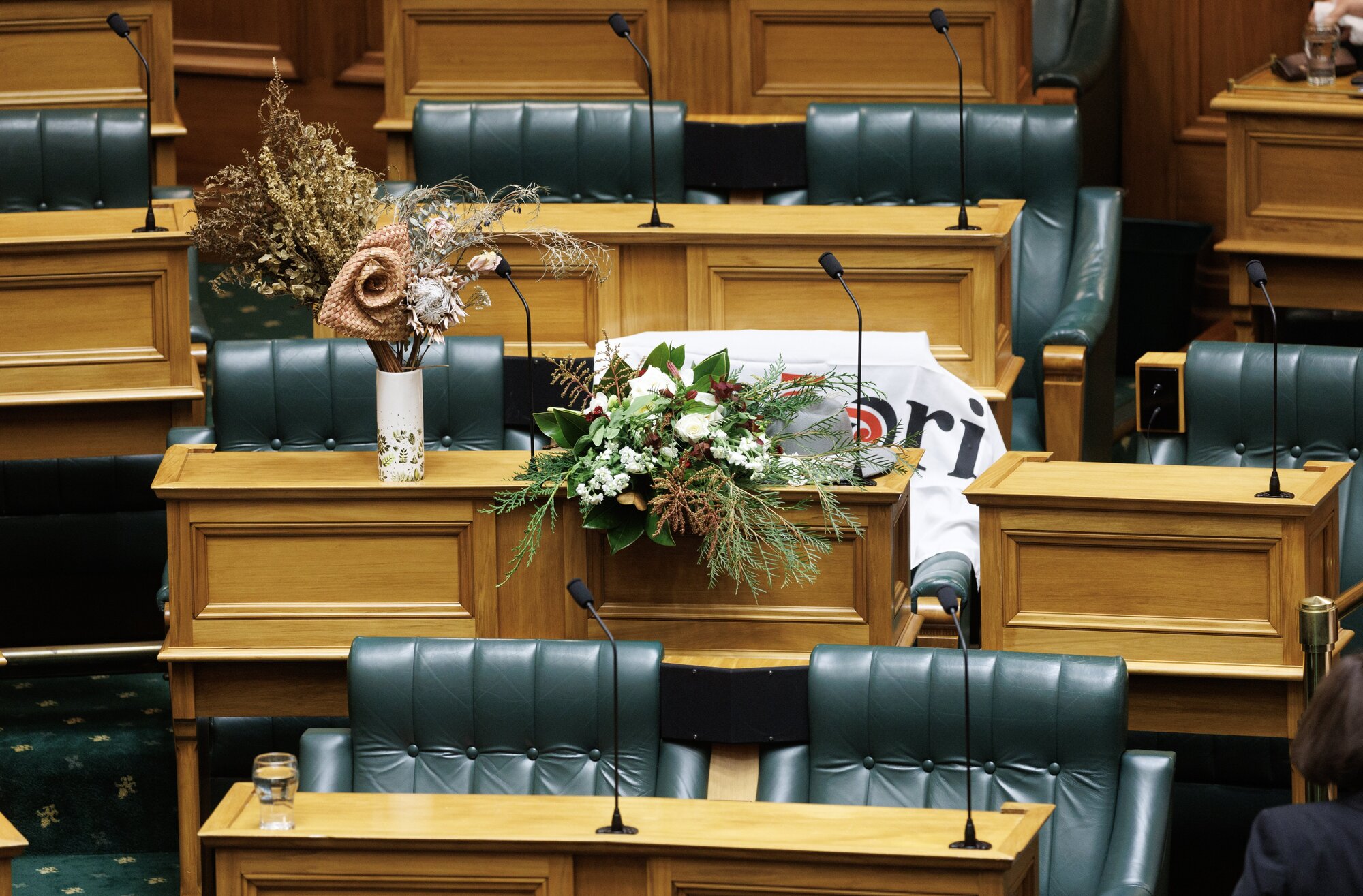 Te Pāti Māori MP Takutai Tarsh Kemp's seat is adorned with flowers and a party flag in Parliament on Thursday. Photo / Mark Mitchell