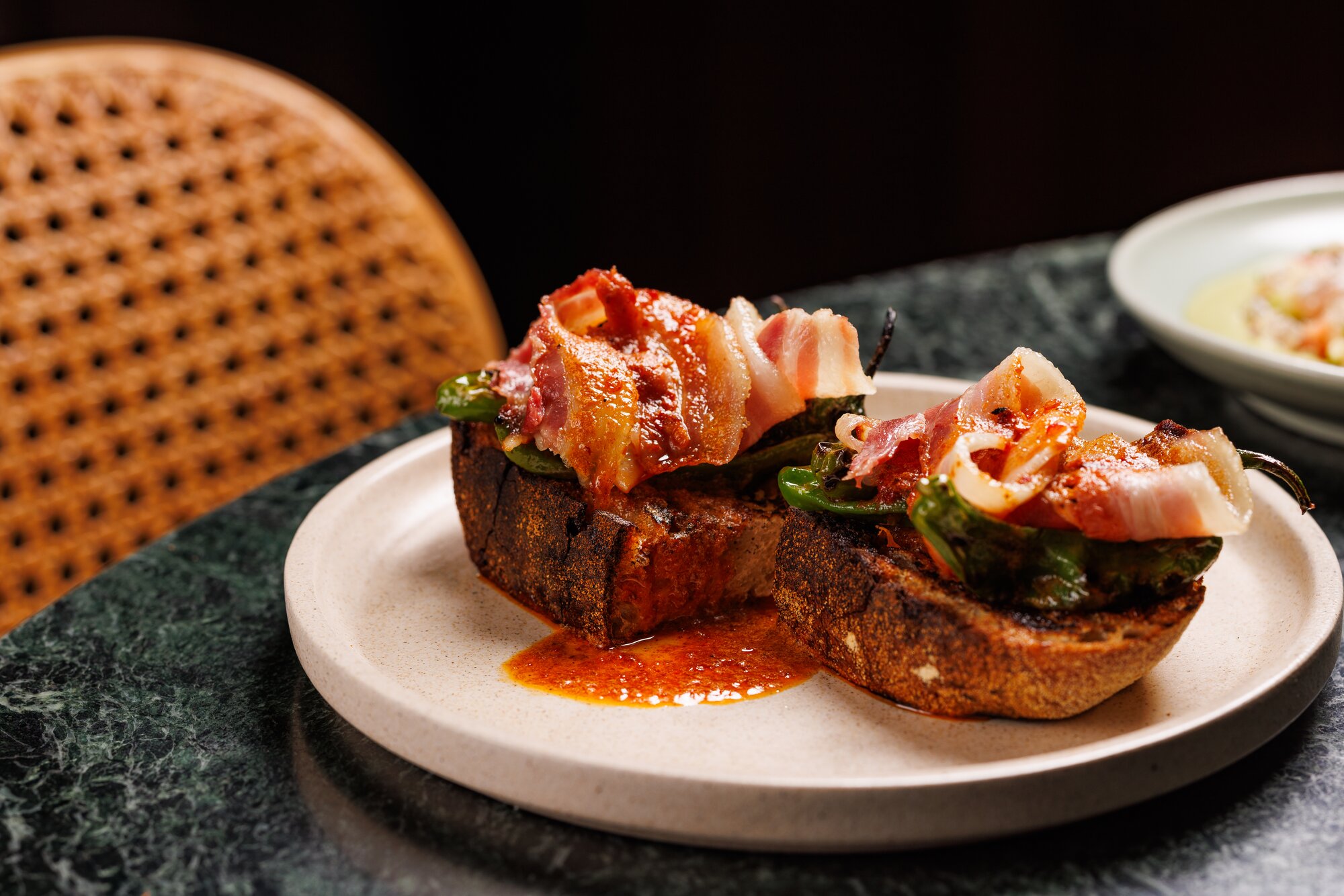 At Hugo's Bistro shishito peppers come tartine style - blistered and smeared on a slice of good focaccia. Photo / Babiche Martens
