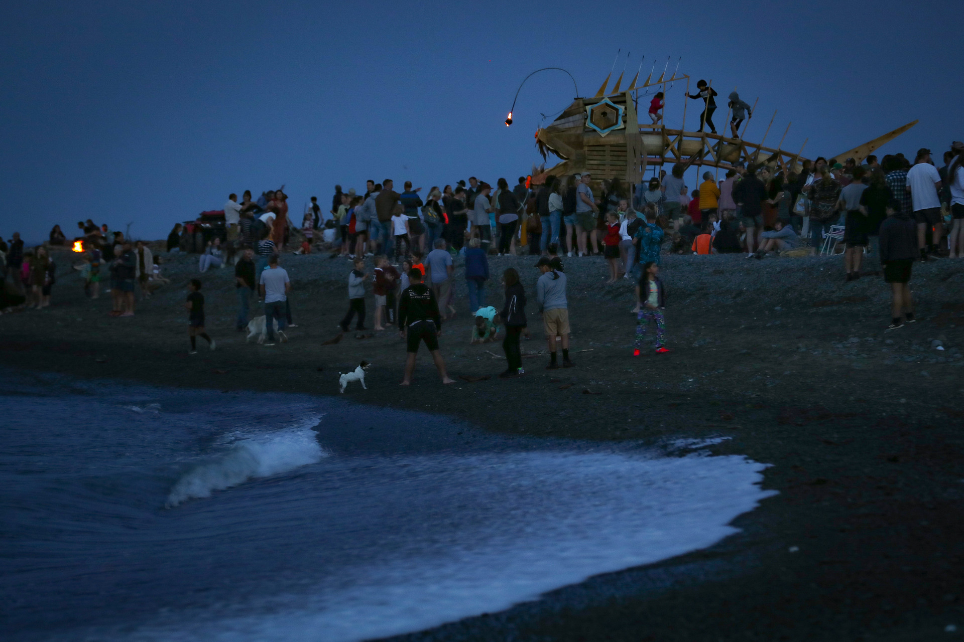 People gather as the sculpture gets in position to be set alight. Photo / Warren Buckland