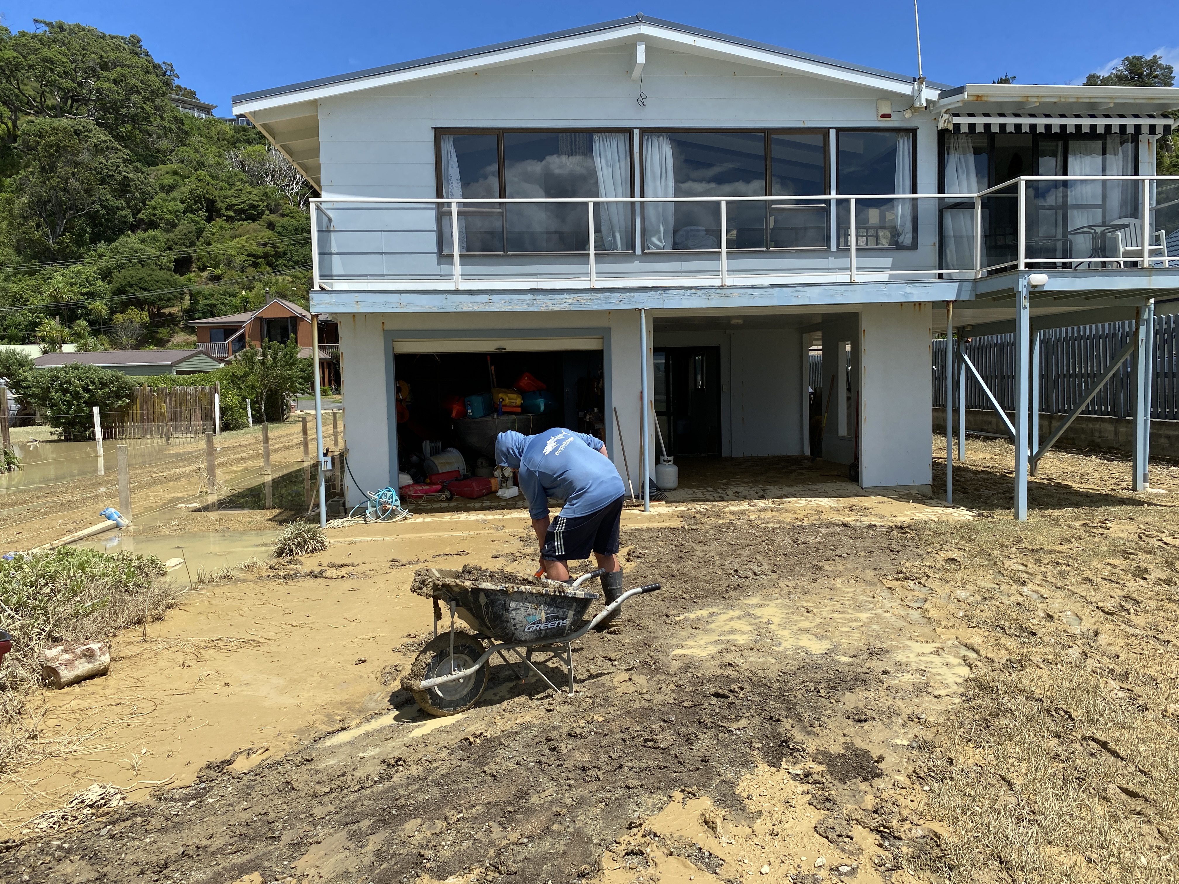 This family holiday home in Ōakura was inundated by water on Sunday, then muddy water on Wednesday, with the drains likely blocked by the slips, family member Mark, who didn't want to give his last name, said. He was busy cleaning up on Friday. Photo / Denise Piper