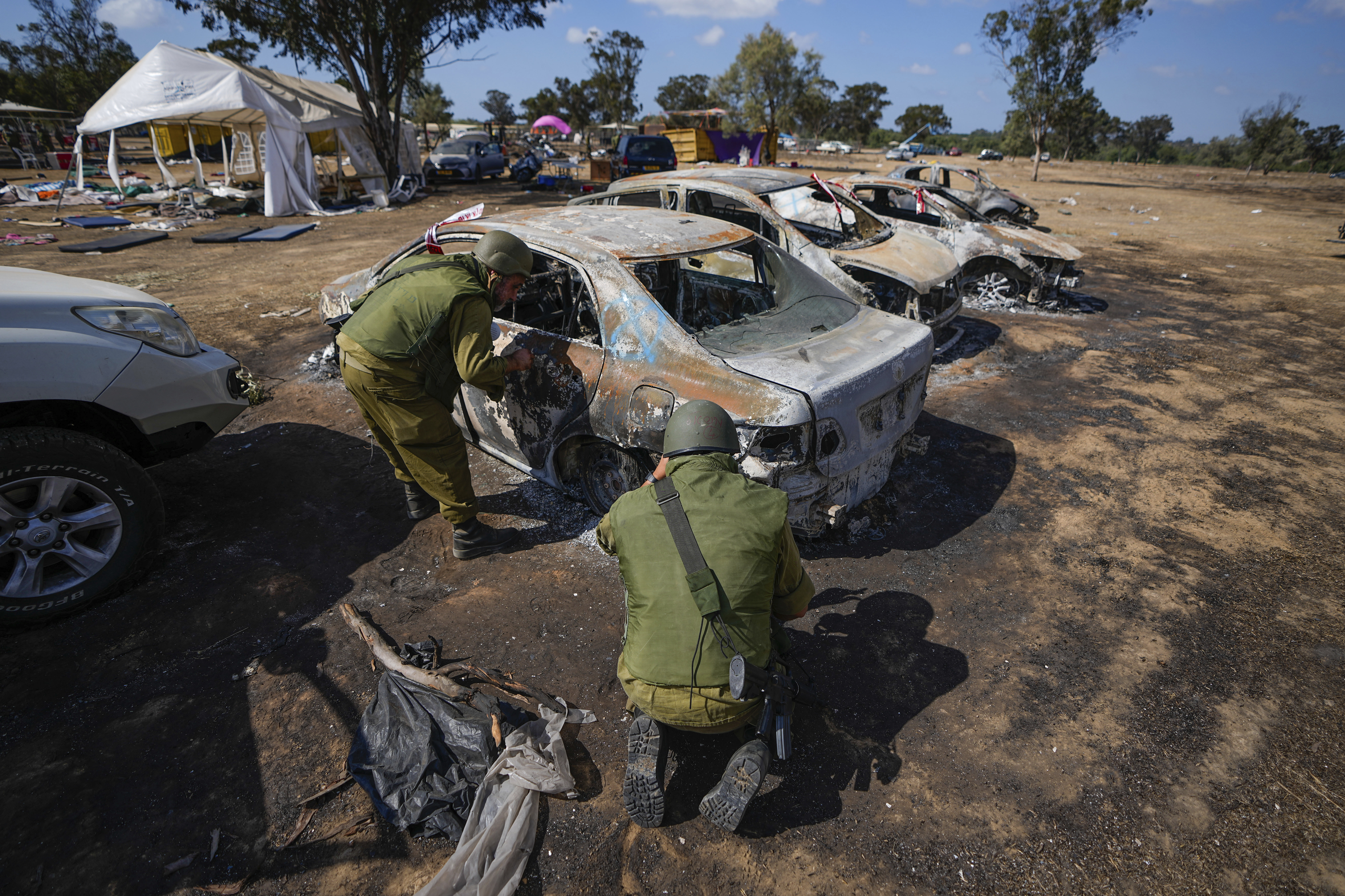 Israeli soldiers inspect the site of a music festival near the border with the Gaza Strip in southern Israel. Photo / AP