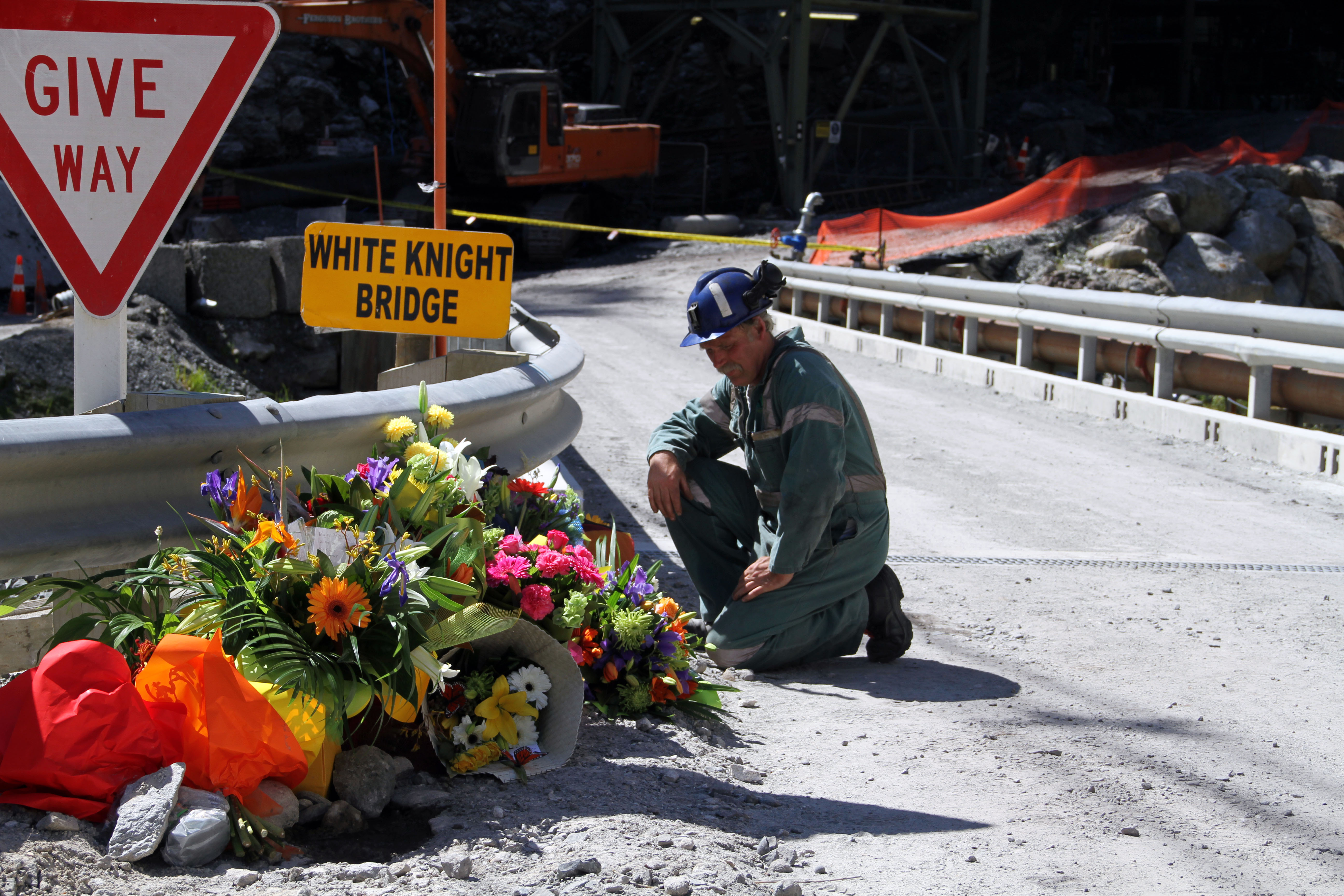 A miner laying down flowers at the White Knight Bridge near the entrance to the Pike River mine. Photo / NZPA