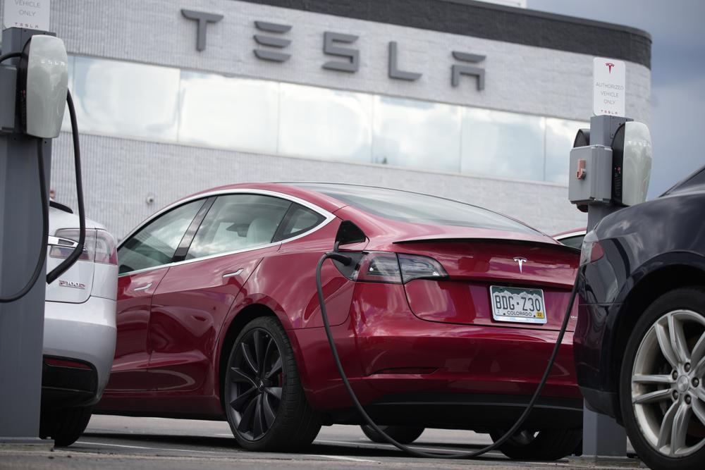 A 2021 Model 3 sedan is connected to a charger at a Tesla dealership. Photo / AP