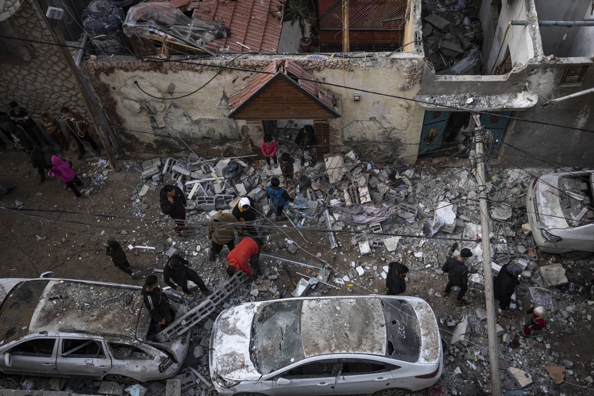 Palestinians look at the destruction after an Israeli airstrike in Rafah, Gaza Strip. Photo / AP