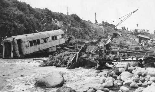 A wrecked carriage and the crumpled remains of the bridge following the Tangiwai disaster in 1953.