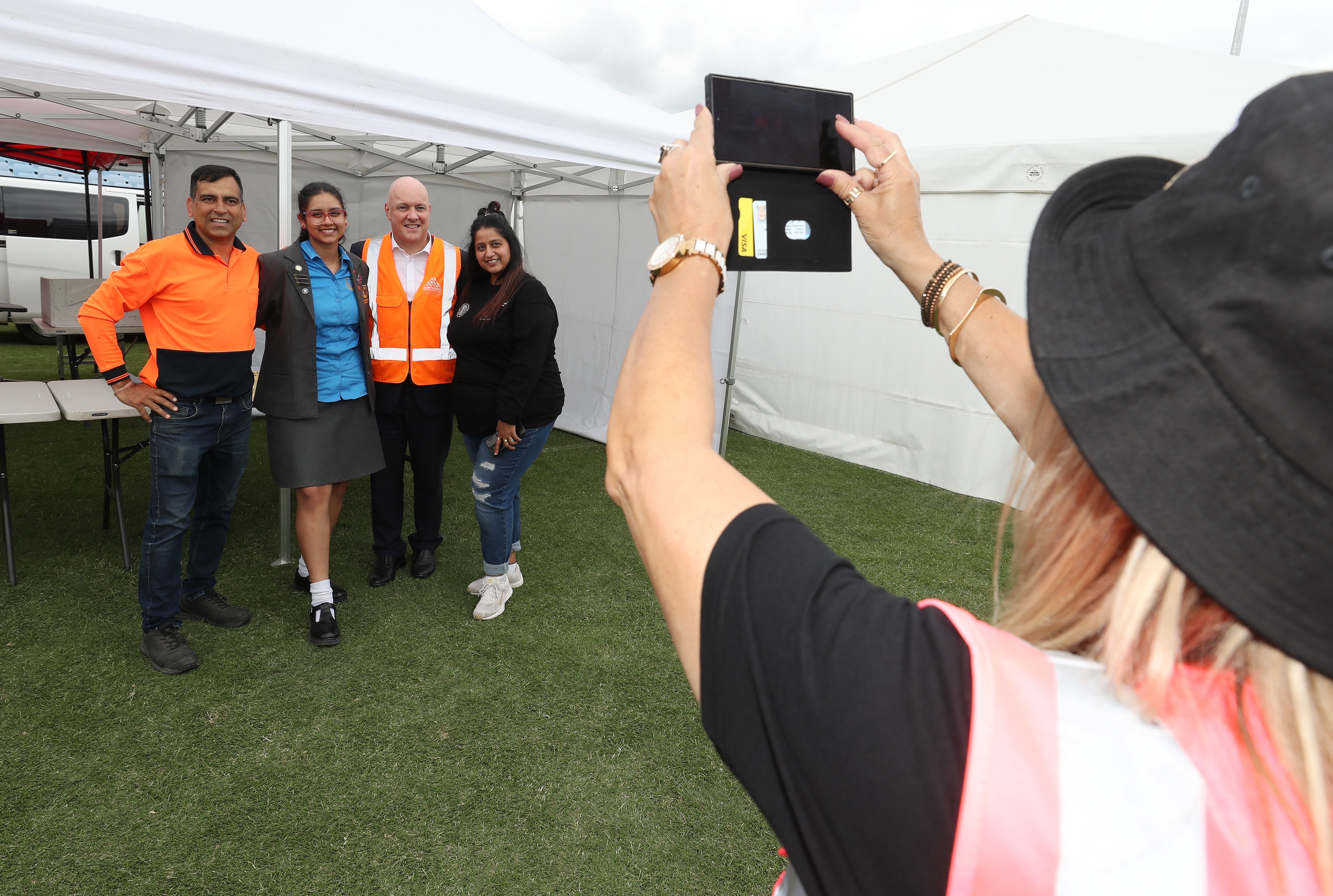 Christopher Luxon poses for a photo with Ajay, Priyal and Simran Sharma from Whangārei food business Authentic Flavours. Luxon said he wanted to get a photo with 17-year-old Priyal before she becomes famous. Photo / Michael Cunningham