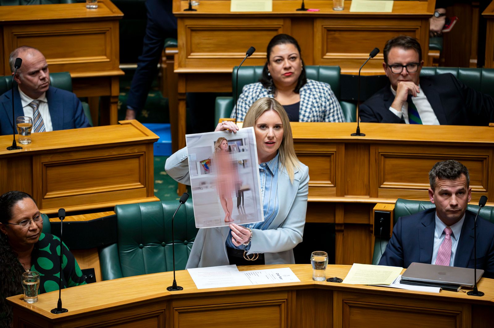 Act MP Laura McClure shows an AI-generated deepfake nude photo of herself in the House. Photo / Supplied