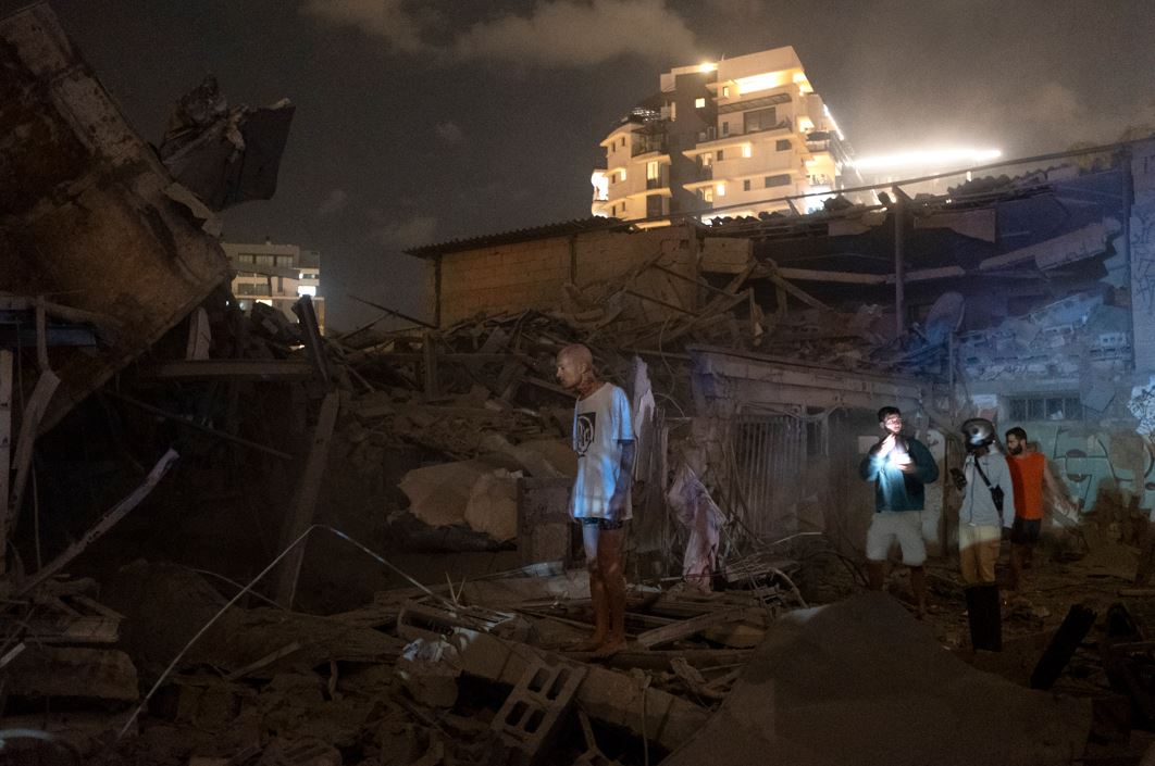 People in Tel Aviv look at the damage from a rocket fired from Gaza.  Photo / AP
