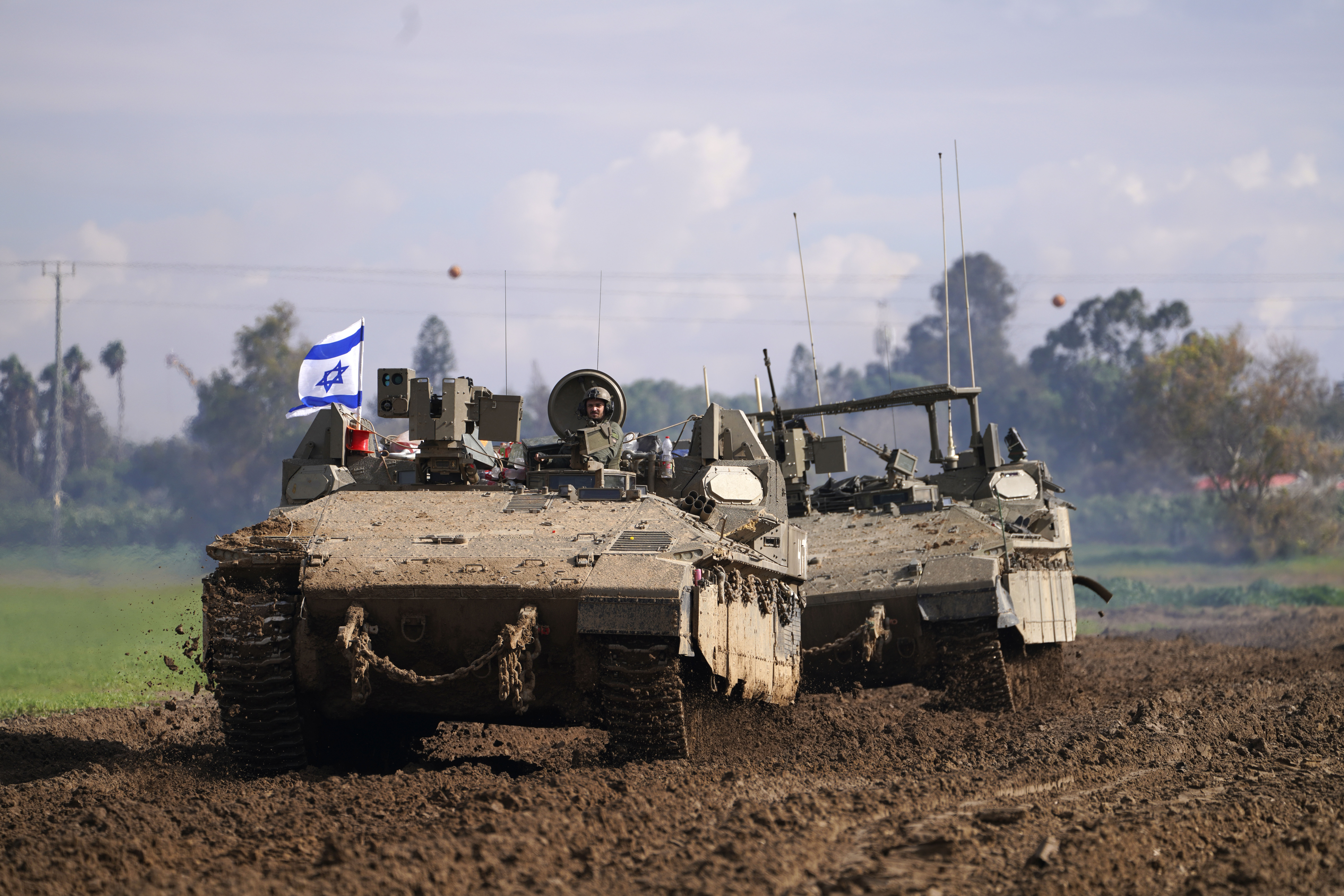 Israeli soldiers drive in their armoured vehicles in southern Israel near the border with the Gaza Strip during ongoing ground operations, on February 2. (AP Photo/Tsafrir Abayov)