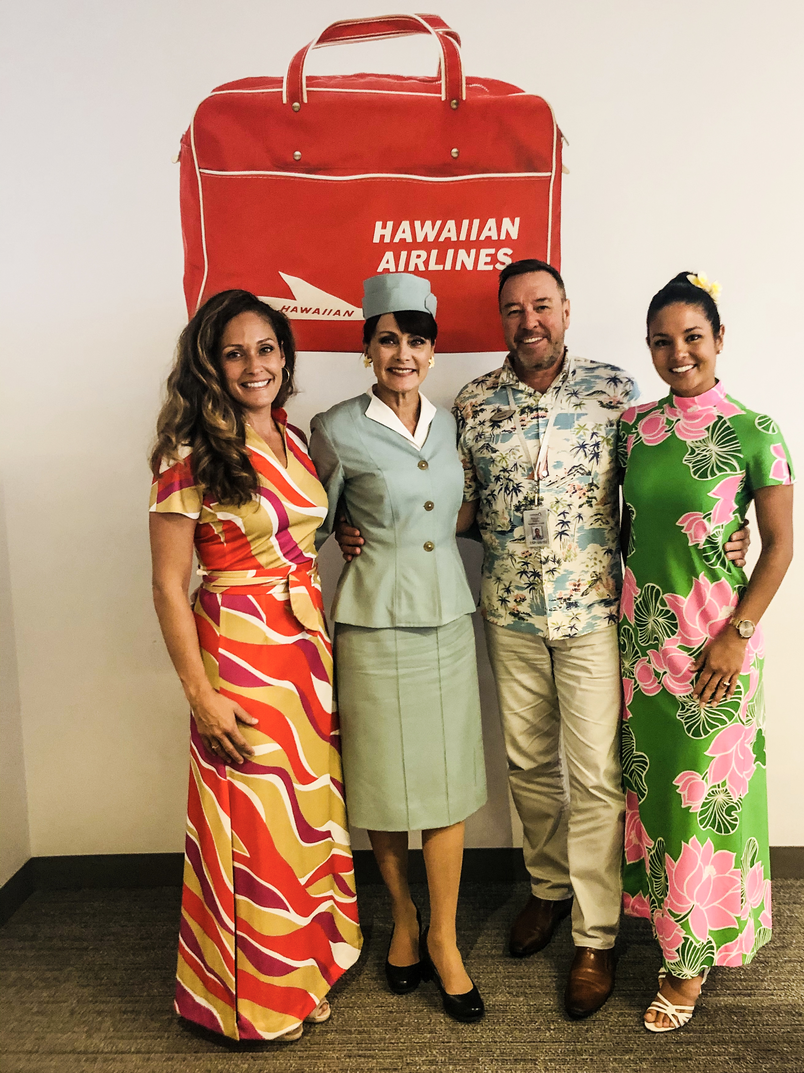 Russell Williss with airline crew in retro uniforms.