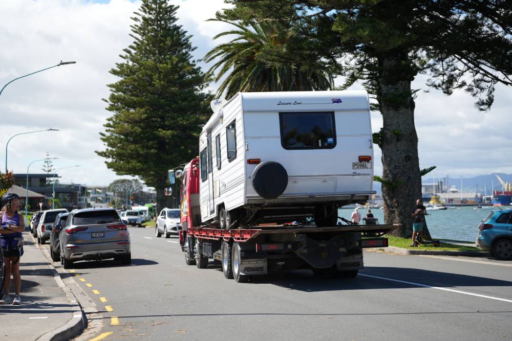 A campervan leaves the Mount Maunganui Beachside Holiday Park on the back of a tow truck. Photo / Alyse Wright