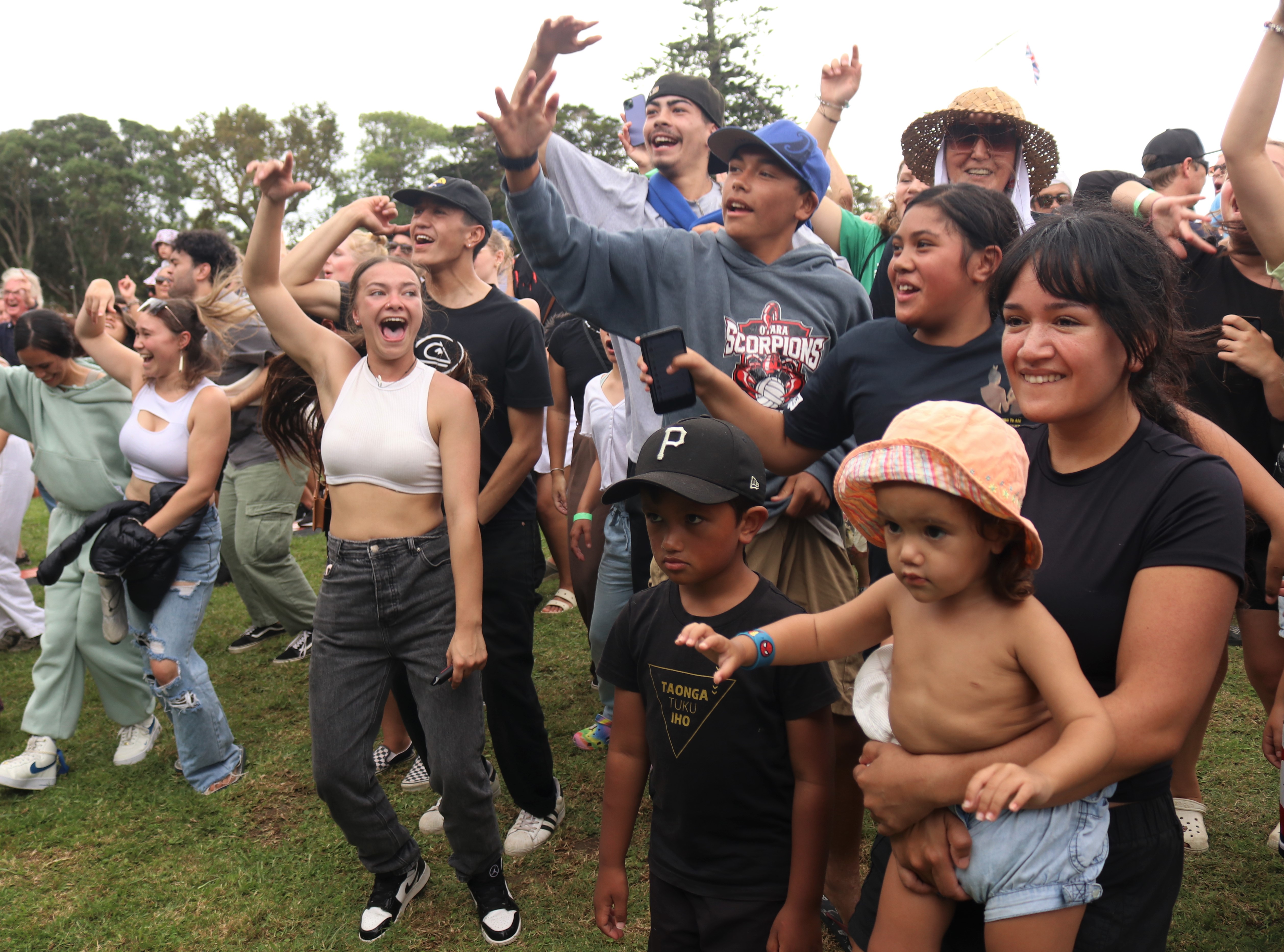 Nikora Hita of Whangārei holds two-year-old Arihia Edge during a Treaty Grounds show by singer-songwriter Troy Kingi. Photo / Peter de Graaf