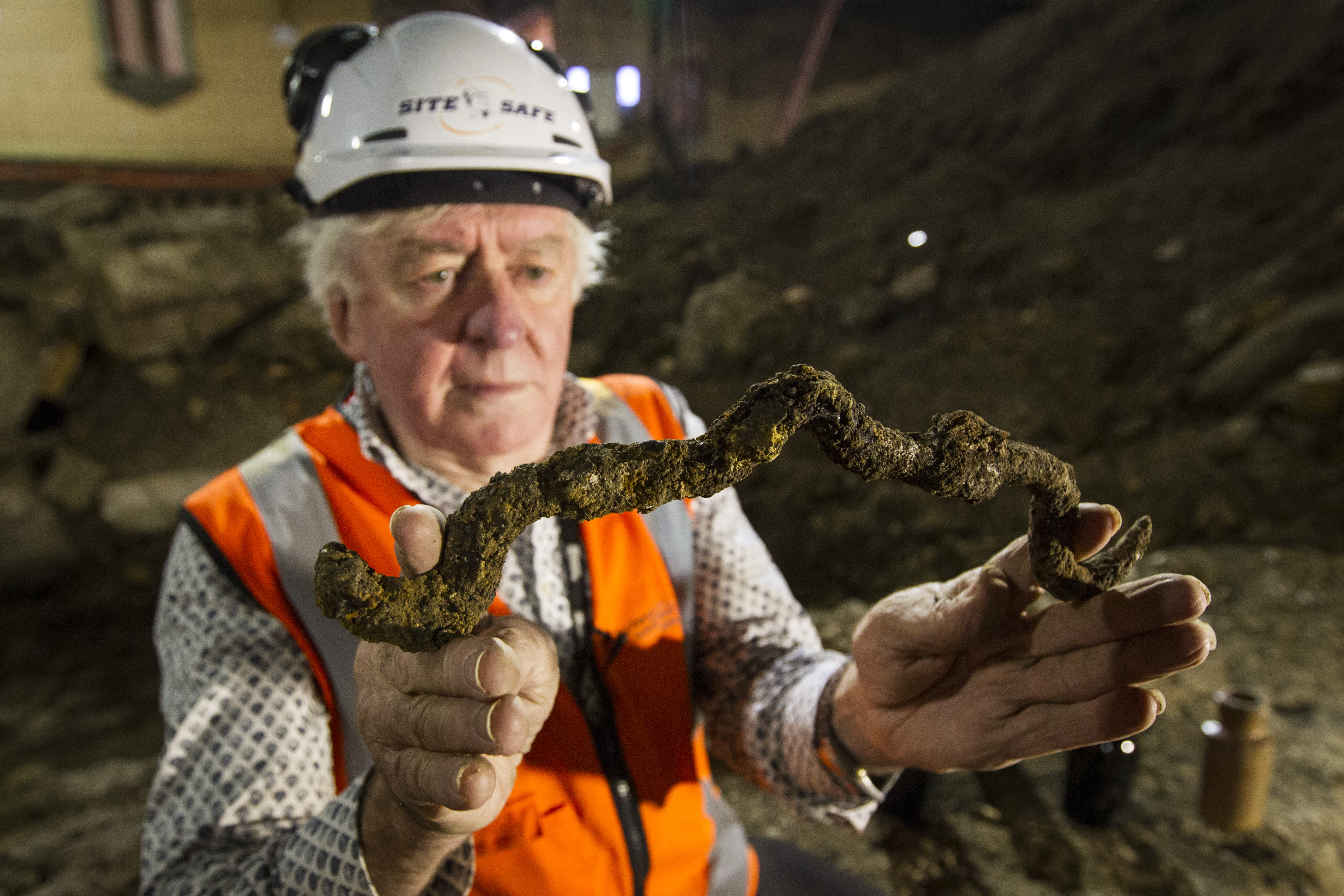 Auckland City Heritage adviser George Farrant studies a butchers hook discovered during the archaeological works of the St James Theatre. Photo / Jason Oxenham