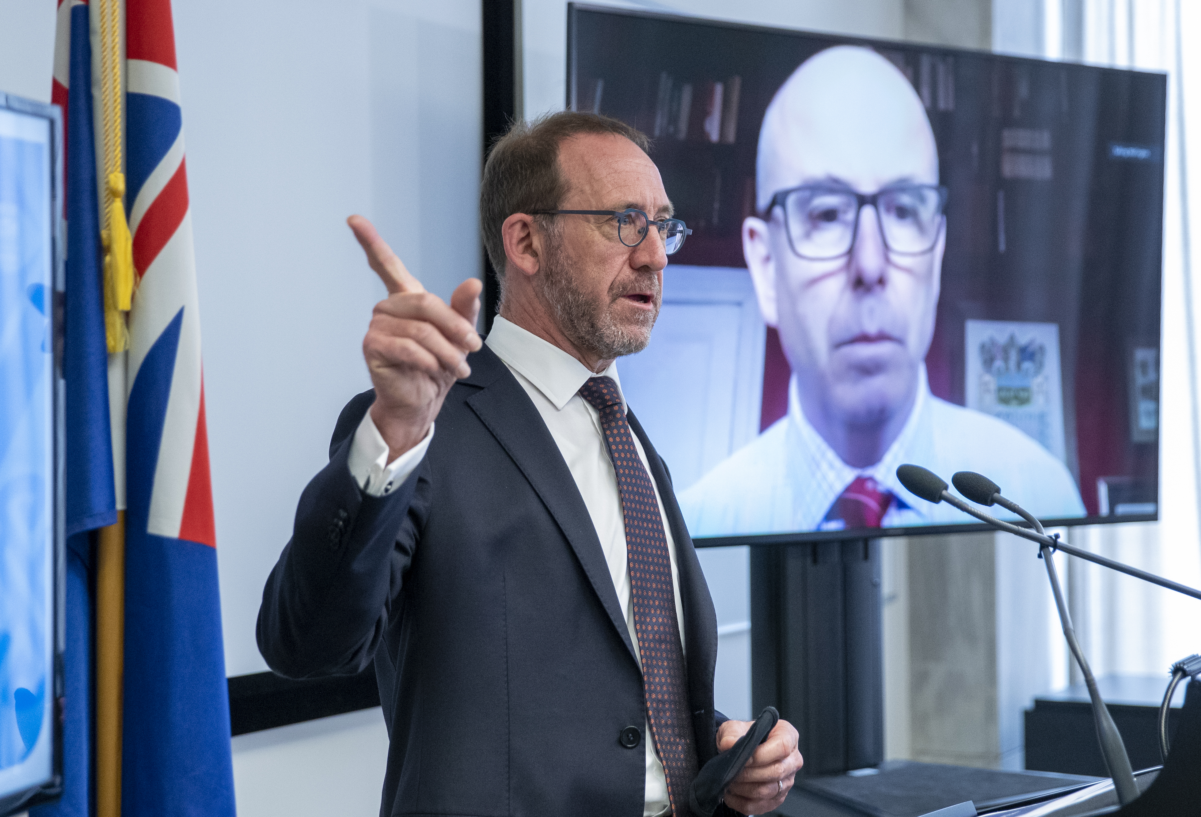 Then Health Minister Andrew Little speaking at Parliament last year. On the screen behind him is surgeon Andrew Connolly, who was chosen to lead a planned care taskforce. Photo / Mark Mitchell