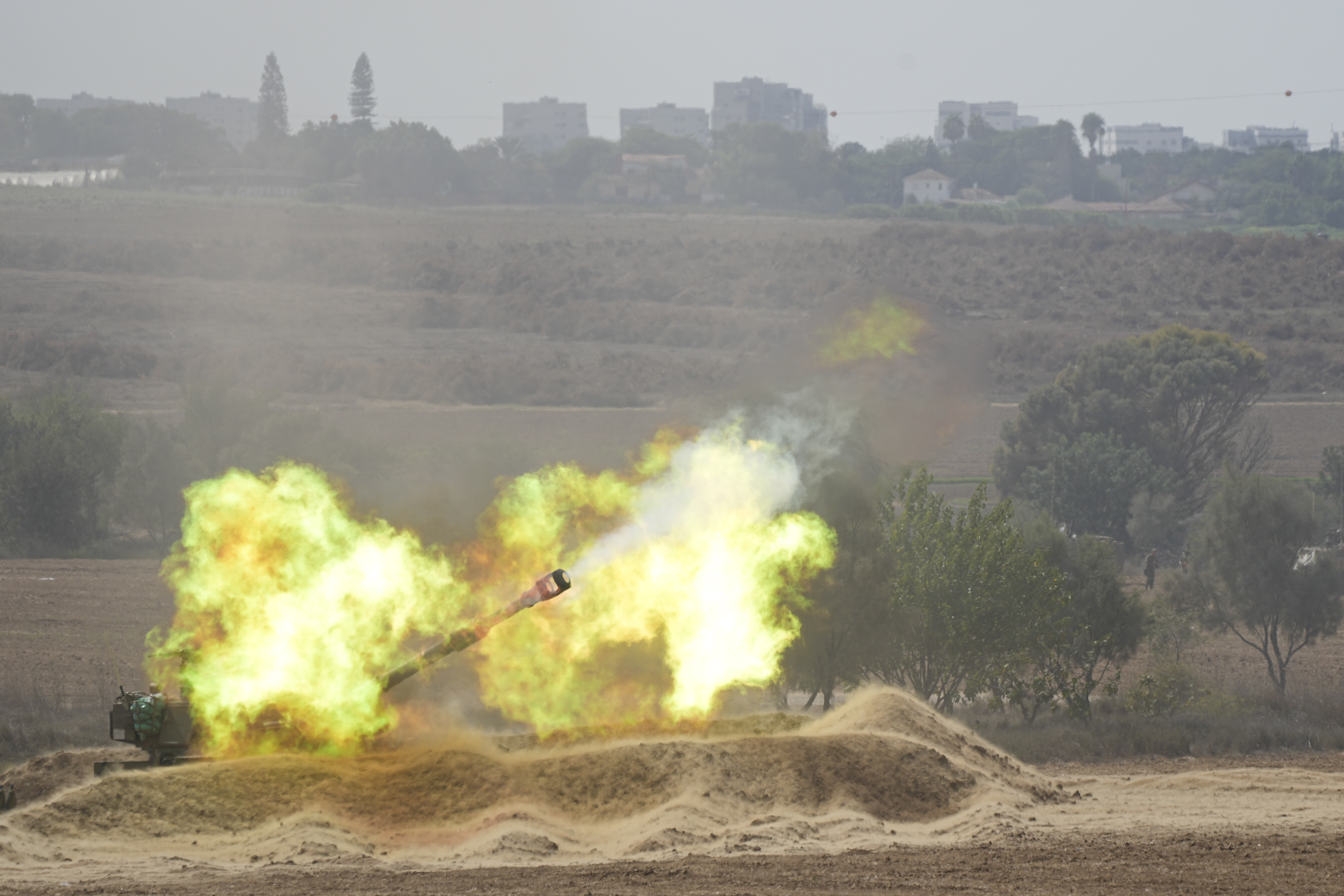 An Israeli howitzer fires at the Gaza Strip from the south of Israel. Hospitals in Gaza are overwhelmed as is the morgue. Photo / AP