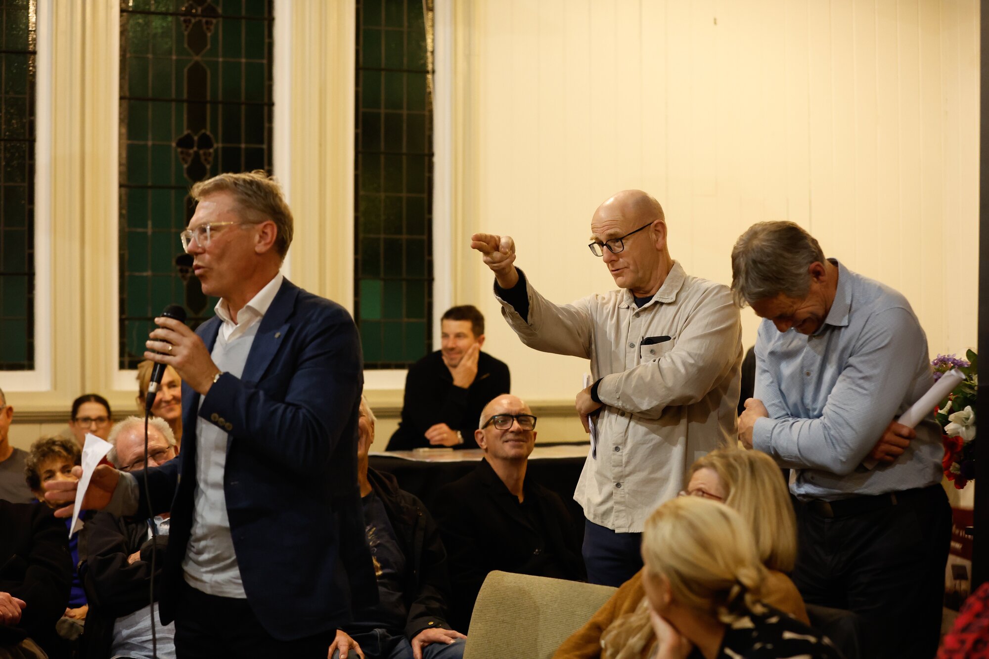 Orakei Local Board member Troy Churton makes a finger gun gesture at local MP and Cabinet minister Paul Goldsmith, at a meeting in Mt Eden. Photo / Sylvie Whinray